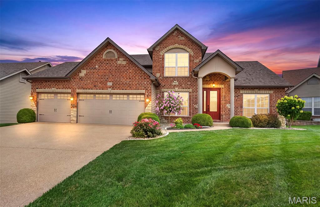 Beautifully maintained 1.5-story home in the heart of O'Fallon offering exceptional curb appeal with professional landscaping and outstanding indoor and outdoor living spaces. Step inside to a dramatic great room featuring a cozy natural gas fireplace and a stunning wall of windows that fills the home with natural light. The open floor plan flows seamlessly into the oversized kitchen, complete with custom cabinetry, a large center island, granite countertops, stone tile backsplash, and gorgeous hardwood flooring throughout the main living areas—perfect for everyday living and entertaining. The spacious main-floor primary suite offers a relaxing retreat with a beautiful window, walk-in closet, and luxurious ensuite bath featuring a double vanity, whirlpool tub, and separate shower. A dedicated main-floor home office provides the ideal space for working from home, while the convenient main-floor laundry room adds everyday functionality. Upstairs, you'll find three generously sized bedrooms, a full bathroom, and an inviting loft that overlooks the great room below, creating an open and airy feel. Additional highlights include a heated and insulated garage complete with a slop sink, as well as an unfinished basement that is already roughed in for a future bathroom, providing endless possibilities for additional living space. Step outside to enjoy the beautifully landscaped yard featuring a custom paver patio and built-in firepit—perfect for relaxing evenings or entertaining family and friends. Residents also enjoy outstanding neighborhood amenities, including two community swimming pools, adding even more opportunities for recreation and relaxation. This exceptional home combines quality craftsmanship, thoughtful design, and an ideal O'Fallon location. Don't miss your opportunity to make this beautiful home yours!
