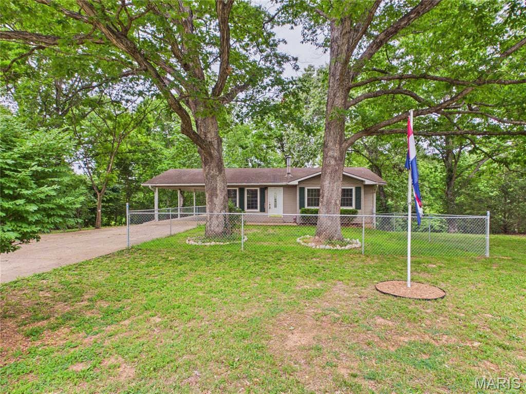 Nestled on a gentle, tree dotted lot that backs up to a peaceful wooded area, this updated two bedroom ranch offers comfortable one level living with a fully finished walkout basement. The main floor features a bright living room, a dining area, and a kitchen equipped with a dishwasher, electric oven, and refrigerator, all tied together with durable luxury vinyl plank flooring. Both main floor bedrooms are conveniently located near a full bath.
Downstairs, the expansive walk out basement doubles your living space with a massive family room anchored by a cozy, free standing wood burning fireplace. The lower level also includes a second full bathroom, a dedicated laundry room, and a separate storage room.
Outside, you can enjoy the private, chain link fenced yard from the comfort of the covered front porch, the back deck, or the patio space. Complete with an attached one car carport, an architectural shingle roof, and insulated windows, this home sits in a quiet neighborhood just a short drive down Highway 34 / 49 from the heart of Piedmont.