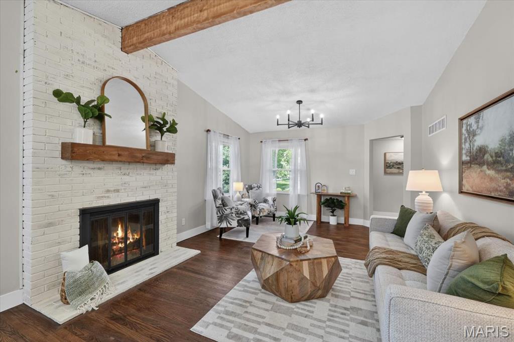 Experience the perfect harmony of modern luxury and preserved character in this stunningly renovated ranch. Situated on a sprawling half-acre lot, this 3-bedroom, 3-full bathroom home has been transformed from top to bottom with high-end finishes and thoughtful architectural details. The interior features two distinct living areas, offering incredible space for relaxation and entertaining. The main living room boasts vaulted ceilings, an exposed rustic beam, and a classic wood-burning fireplace with white-washed brick. A second living area also features vaulted ceilings and exposed beams, flooded with natural light from a large skylight while overlooking the designer kitchen. The kitchen itself is a true showpiece, featuring custom-built cabinetry, gleaming quartz countertops, and a social island. In the formal dining room, original built-in corner hutches have been beautifully preserved, while refinished original hardwood floors run throughout the main level. All three full bathrooms feature designer upgrades, including marble penny tile, sophisticated board-and-batten wainscoting, and custom vanities with modern hardware. Doubling your living space, the lower level features a large recreation area, a bonus room (ideal for an office or guest suite), a third full bathroom, and an expansive storage wing. Hobbyists will love the dedicated workshop area located right off the garage, and you'll have total peace of mind with new energy-efficient windows across the entire home.