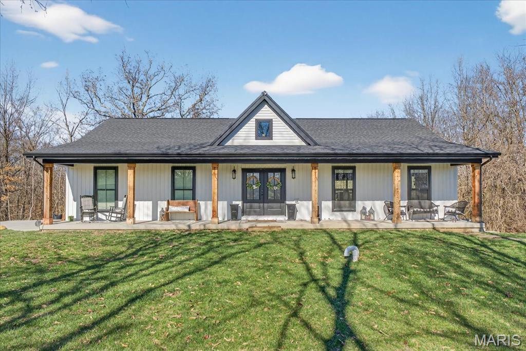 Welcome to your own private retreat at 8104 Brickyard Hill Rd in Worden, IL, where peaceful, serene living meets modern luxury situated on over 2 acres with a beautiful pond of which approximately 75% is included with the property offering a rare opportunity for added privacy and enjoyment. Built in 2023, this gorgeously crafted home welcomes you in from an impressive 56-foot covered front porch, setting the tone for the warmth and charm found throughout. Inside, you’ll find stunning hickory wood flooring across the main level, soaring vaulted ceilings, and a cozy fireplace that creates the perfect gathering space. The heart of the home is a true gourmet kitchen, featuring a sprawling 12-foot granite countertop, built-in butcher block cutting board, stainless steel appliances, and a spacious walk-in pantry currently styled as a home office for added versatility. The main floor primary suite is a true escape, offering a spa-like bathroom with a soaking tub, separate shower, and double vanity. The bedroom includes a walk-in closet and direct access to a 32-foot covered deck overlooking your private, wooded backyard, perfect for morning coffee or unwinding at sunset. The finished walkout lower level expands your living space with a large family/recreation area, three additional bedrooms, a full bath, and ample storage. Adding even more value and charm is a beautifully finished tiny home, perfect as a studio, guest space, or she- shed featuring a living area, lofted sleeping space, bathroom, and its own heating and cooling Step outside to enjoy the patio and firepit area, designed for entertaining or quiet evenings under the stars. With minimal light pollution, the night skies here are absolutely breathtaking. Additional features include a Generac system and smart locks throughout for comfort and peace of mind. This is more than a home, it’s a lifestyle