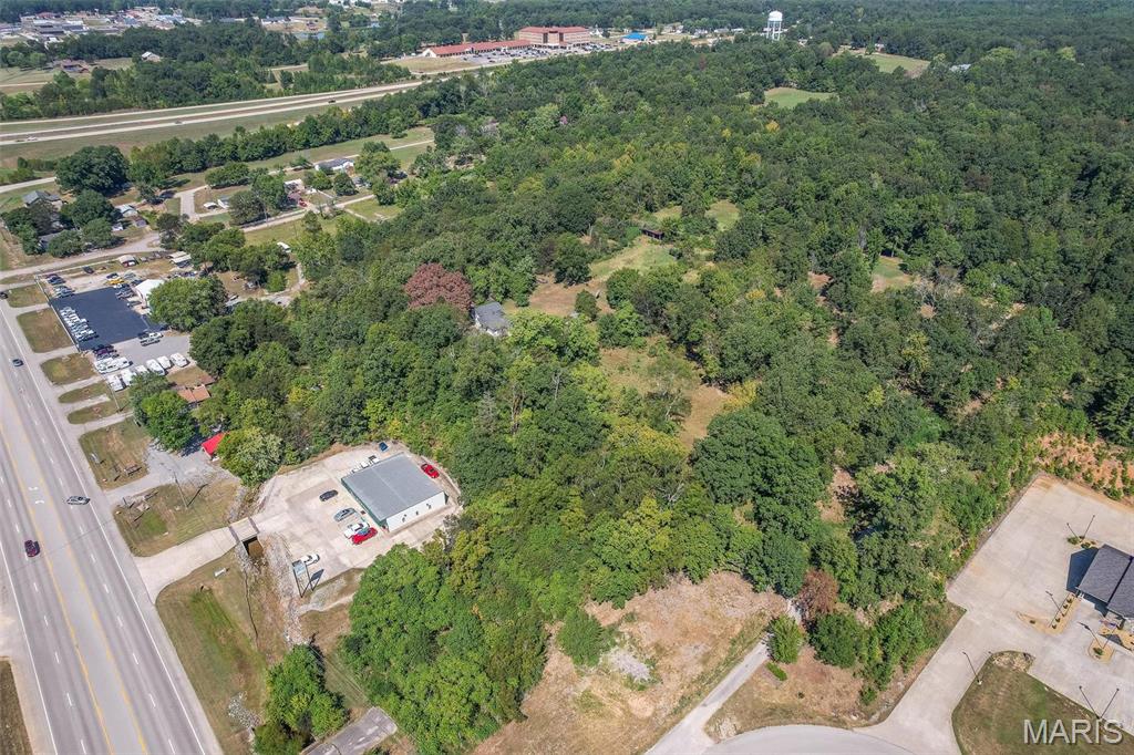 Everything has a lifecycle - including this beautiful 6.64 m/l acres of commercial land within the city limits just waiting for you to create the development of your dreams.  Follow the lane up to the home built in 1958 with outbuildings and acreage which is now ready for you to buy and breathe life to your own dreams - multi-family dwellings, retail, healthcare facility - you name it!  Call today to see this gorgeous property with endless possibilities and develop it into your vision!