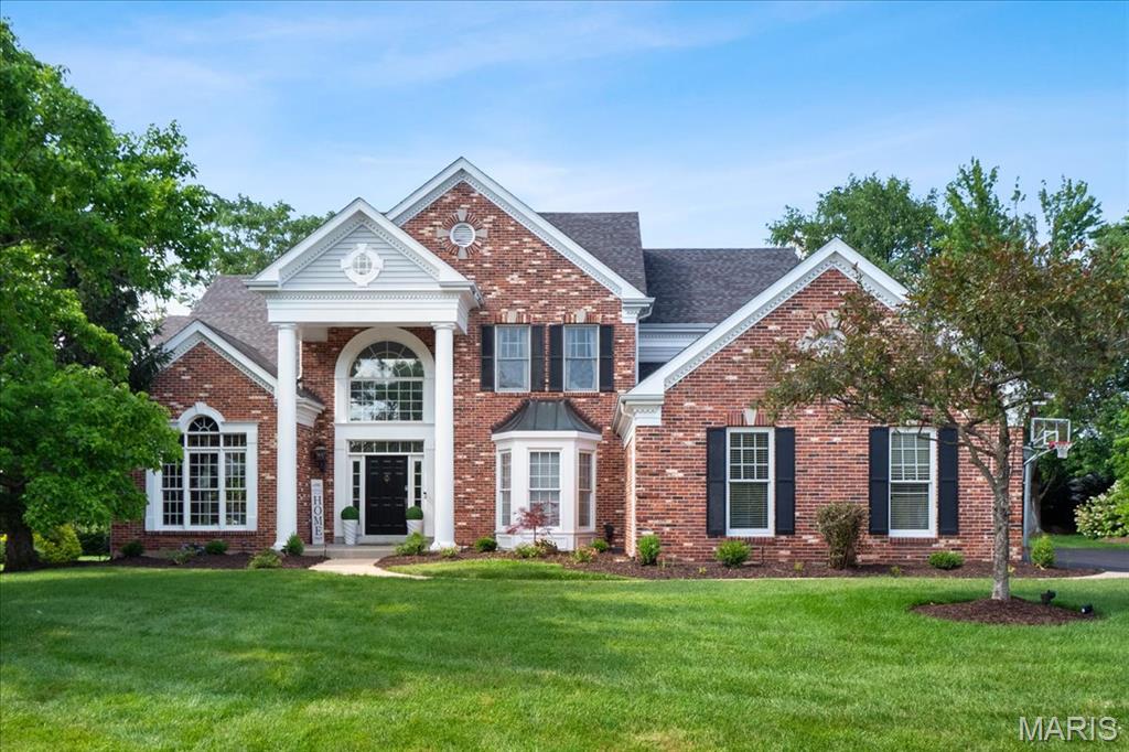 Welcome to one of the finest homes in Manderleigh of Town & Country—this stately brick 1.5 story offers timeless elegance and unmatched space. The grand marble foyer with sweeping staircase leads to a paneled library, formal dining room, and a soaring great room with floor-to-ceiling windows, brick fireplace, and built-ins. The gourmet kitchen boasts 42” cabinets, granite countertops, premium appliances, a center island, and butler’s pantry, opening to a vaulted hearth room and sunny breakfast nook. The main-level primary suite features dual walk-in closets and a spa-like bath with His & Hers vanities and a Jacuzzi tub. Upstairs you'll find three spacious bedrooms and well-appointed baths. The finished lower level includes a theater room, full guest suite, kitchenette, gym, two rec areas, office/den, and two full baths. All set on a beautifully landscaped lot with a 3-car garage and patio. A rare find in an unbeatable location!