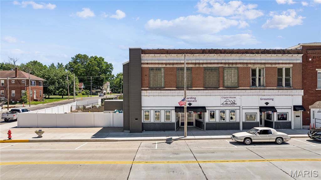 Are you ready to own the only kennel permitted within Staunton city limits? Then look no further than this rare commercial opportunity in the heart of downtown. 124 E Main Street is a fully operational, turnkey animal care facility sitting on over 14,000 square feet of lot space and built out across three levels to handle serious volume. The basement level features an extensive kennel operation with over 20 individual kennels of varying sizes, thoughtfully arranged to maximize capacity, along with dedicated storage to keep operations running efficiently behind the scenes. 
The main floor is the core of the day-to-day business, delivering a professional wash room, a full grooming salon, dedicated day boarding space, a cattery, and a private office, all flowing into a large outdoor patio and exercise area that gives animals room to move in a secure, fenced environment. 
The second floor offers multiple rooms with a kitchen, opening the door to owner-operator or live-in management, a setup that keeps overhead low and puts you steps away from your overnight boarding operation. In addition, the property includes a 2 bed/1 bath apartment currently rented at $900/month. A detached garage adds additional storage or equipment space, and the brick construction with chain link and vinyl fencing already in place means the infrastructure is ready to produce income without a long list of capital improvements standing between you and your first client. Not to mention the special-use permit barring any other kennel to operate within the city of Staunton; creating a protected market for your investment. The location itself is also a business asset.  Staunton sits along Historic Route 66 just off Interstate 55 and Illinois Route 4, with more than 27,500 vehicles passing through daily, positioning this Main Street property in front of consistent, high-volume traffic. The city is just 25 minutes north of downtown St. Louis and 50 minutes from Springfield, giving the business a natural draw from a broad surrounding population looking for quality pet care without competitive city prices. Call today to schedule your private tour!