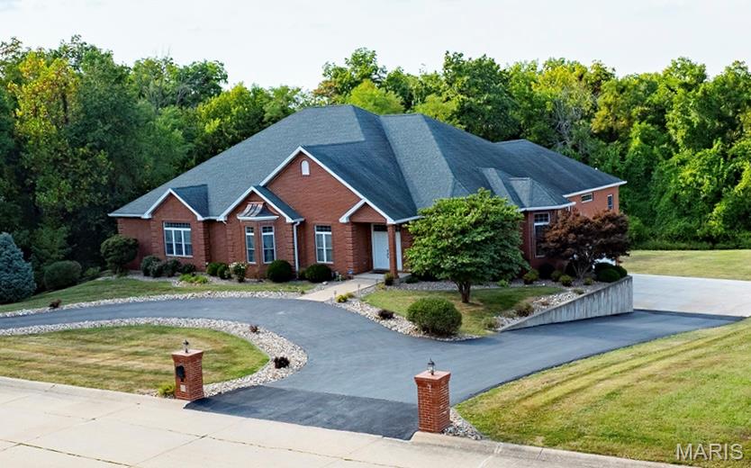 NEW PRICE! Welcome to this exceptional one-owner custom-built home, offering nearly 10,000 sq ft of thoughtfully designed space on 2.43-acre lot. Built in 2008, this full-brick home combines timeless craftsmanship with modern comfort. Inside, you’ll find 6 spacious bedrooms—each with private en-suite baths & walk-in closets. The open-concept main level features 10-foot ceilings, a chef’s kitchen with abundant cabinetry and Silestone countertops, SS appliances, double dishwasher, gas range, and a huge walk-in pantry. The kitchen flows effortlessly into the dining area and breakfast room, all bathed in natural light from a stunning wall of windows. The living room features a gas fireplace, custom built-ins, and opens to a year-round sunroom overlooking the private backyard. The primary suite is a true retreat, with closet built-ins and a spa-like bath with jetted tub, separate shower, and double vanity. 3 addl bedrooms complete this floor. Downstairs, enjoy a spacious family room with gas fireplace and kitchenette, a theater room with built-in speakers and TV, a dedicated office with French doors and custom cabinetry, plus 2 more bedrooms with private baths. Additional features include a 3-car garage with EV charging station, hidden stairs from the garage to the kitchen. The walk-out basement leading to a concrete patio—perfect for entertaining or relaxing. This maintained home blends comfort, functionality, and elegance—ideal for multigenerational living or hosting on a grand scale.