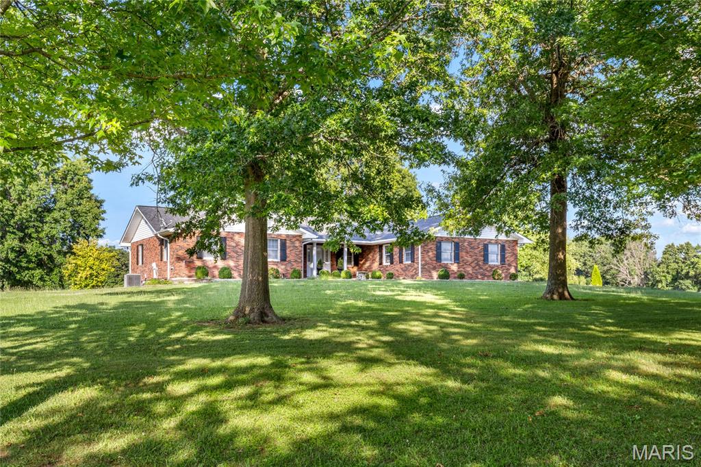 Spacious full-brick ranch home situated on 25 scenic acres well-suited for a variety of agricultural & recreational opportunities. Wide covered porch entrance leads to formal living room highlighted by gas fireplace with full-height white mantel and adjacent dining room. Just off the main living area, the light-filled family room provides a relaxing retreat. The custom designed kitchen with 42” maple cabinetry, granite countertops, premium appliances & center island opens to an inviting covered patio that offers sweeping vista views of the surrounding countryside. Vaulted primary bedroom with ensuite bath plus a second bedroom, hall full bath & convenient laundry complete the main floor living quarters. The walk-out Lower Level extends the living area with a galley kitchen, bonus room & full bath.  In addition, the property features a 53’ x 30’ drive-through barn with 10' overhead doors & is equipped with 200 amp service. Located just west of Troy with its charming historic district & acres of scenic parks.