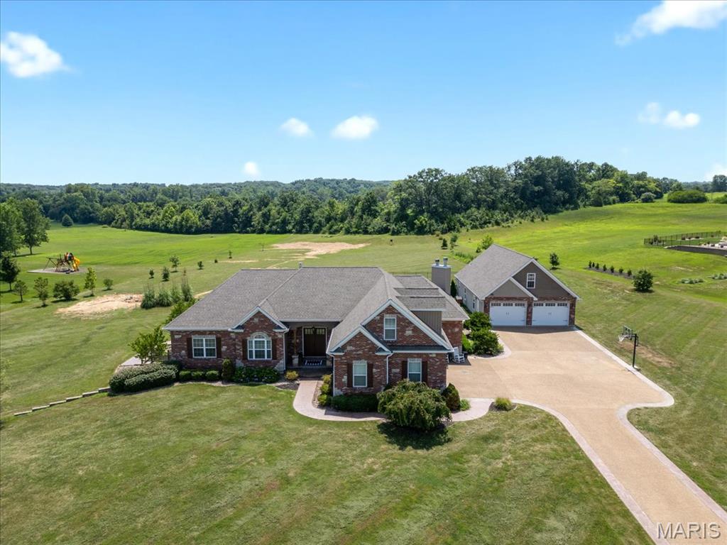 EXQUISITE, CUSTOM, ranch home w/upper level bonus bedroom, resting gracefully on 3+/- acres providing peace & tranquility within desired subdivision of Avondale Park! Boasting a private oasis inground heated saltwater pool, 2-car oversized detached garage w/half bath, 2-car attached garage, NEWLY finished basement, 5 bedrooms, 4 full & 1 half bath with 5,796+/- sqft. Covered front porch welcomes you as you step inside the entry foyer. Wood flooring throughout most of main level. The spacious living room boasts 14'+/- ceiling, gas fireplace & wall of windows with walk-out to patio/backyard. An open eat-in, chef’s kitchen with custom cabinetry, Quartz, stainless steel appliances, breakfast & dining area, hearth, walk-in pantry & numerous vaulted ceilings taking the rooms to new heights. Primary suite with 14'+/- tray ceiling, French door entry, 2 walk-in closets, walk-out to patio, dual sink vanities, custom shower, jet tub & private commode. 2 Bedrooms with carpet & walk-in closets share Jack&Jill. Laundry room & half bath complete the main level. Upper level offers a large bedroom with carpet & ensuite full bath. Walk-up lower level extends living with 5th bedroom, large rec room with wet bar & brick wood burning fireplace, full bath, exercise room & office. Privacy galore! Must see!