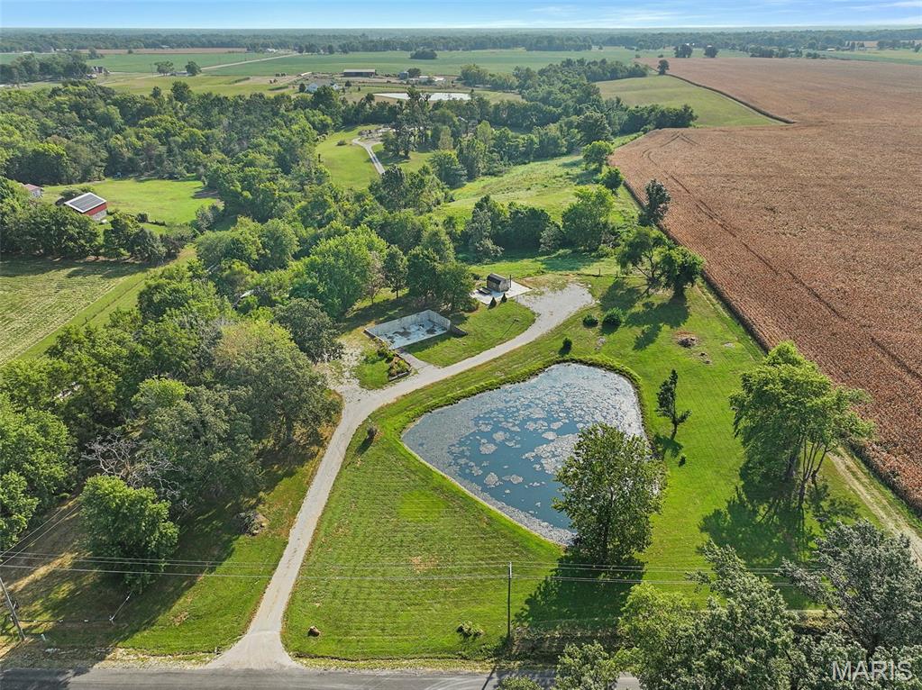It's what you've been looking for! Beautiful 5-acre property just outside of town in the Bethalto School District, complete with a private pond and mature trees. A home previously stood on the property but was destroyed by a tornado. The poured concrete foundation remains intact and includes rough-in plumbing, offering a unique opportunity to potentially build a new home utilizing the existing foundation and significantly reduce construction costs. A large concrete pad from a former outbuilding also remains and may provide the perfect location to rebuild a garage, shop, or additional structure. A smaller shed, some fencing, and utilities are already in place. With its peaceful setting, acreage, pond, and existing improvements, this property offers tons of potential to create something truly special!