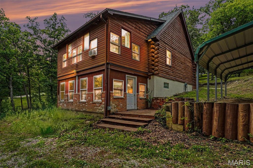 Escape to your own waterfront retreat in the gated Lake Seven Falls community! This charming 4-bedroom, 2-bath log cabin sits on 1.74 wooded acres with direct lake access and offers the perfect blend of rustic character and modern updates. The open floor plan features soaring vaulted ceilings, hardwood floors, a spacious great room, and an eat-in kitchen with breakfast bar. The flexible layout includes two main-level bedrooms, an upper-level loft and bedroom, plus a partially finished walk-out basement with a recreation room, additional sleeping area, and half bath—ideal for guests or extra living space. Relax on the covered front porch, enjoy the peaceful wooded views, or head down to the water from your own property. Recent improvements include a new HVAC system (2021), newer roof and skylights, and refreshed gravel driveway. Additional features include a 2-car carport, three storage sheds, RV/boat storage, and access to two lakes within the community. Whether you're looking for a full-time residence, weekend getaway, vacation home, or investment opportunity, this unique waterfront cabin offers endless possibilities just a short drive from St. Louis and Farmington.