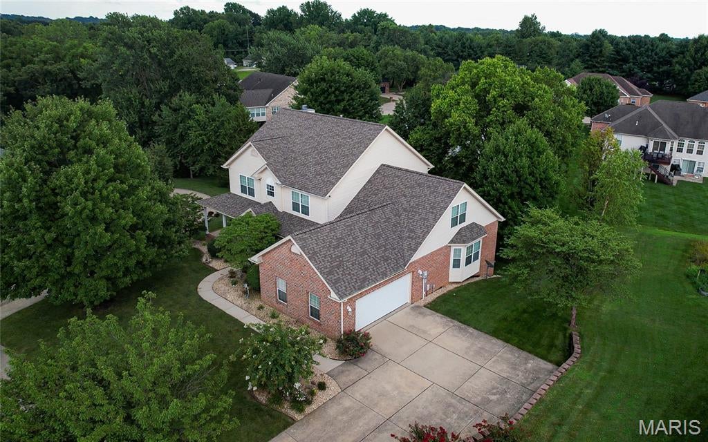 Tucked away on a quiet cul-de-sac in the highly sought-after Wolf Branch School District, this exceptional one-owner home offers the perfect balance of timeless design, generous living space, and meticulous care. Surrounded by mature trees and beautifully maintained landscaping, the property offers approximately 3,000 square feet of finished living space, plus an unfinished 2,000 square foot walkout basement ready to be customized to fit your lifestyle.

A welcoming wraparound porch leads into an impressive two-story great room where soaring ceilings, newly refinished hardwood floors, and a dramatic wall of south-facing windows fill the home with natural light. Designed for both everyday living and entertaining, the main level offers a spacious primary suite with brand new carpeting, a walk-in closet, and a private bath featuring a garden tub and separate shower.

The beautifully updated kitchen is both functional and inviting, featuring new granite countertops, stainless steel appliances, abundant cabinetry, two pantries, and a bright breakfast area overlooking the backyard. Just beyond, the newly remodeled TREX composite deck creates a comfortable outdoor living space surrounded by mature shade and flowering trees.

French doors open to a private library and home office with custom built-in bookcases and cabinetry, providing an ideal space for working from home, reading, or quiet reflection. A formal dining room, powder room, and main floor laundry add convenience and flexibility.

Upstairs, an open loft overlooks the great room and leads to four generously sized bedrooms, each with its own walk-in closet. The oversized fifth bedroom offers exceptional versatility with three closets and a charming window seat with built-in storage, making it equally suited as a guest suite, media room, playroom, fitness studio, or additional office.

The full walkout basement provides an outstanding opportunity to expand your living space with room for a recreation area, home theater, fitness room, workshop, or additional bedrooms while still offering abundant storage.

Recent improvements include a new roof, dual high-efficiency HVAC systems, dual water heaters, cleaned ductwork, refinished hardwood floors, new carpeting throughout the primary suite and upper level, a beautifully remodeled upstairs bath, updated granite countertops, and a remodeled TREX composite deck.

Located just minutes from Scott Air Force Base, shopping, dining, parks, and major highways, this home offers an exceptional combination of privacy, convenience, quality craftsmanship, and thoughtful updates in one of the Metro East's most sought-after communities.

Homes that have been this well cared for rarely become available. This is a property where pride of ownership is evident from the moment you arrive.