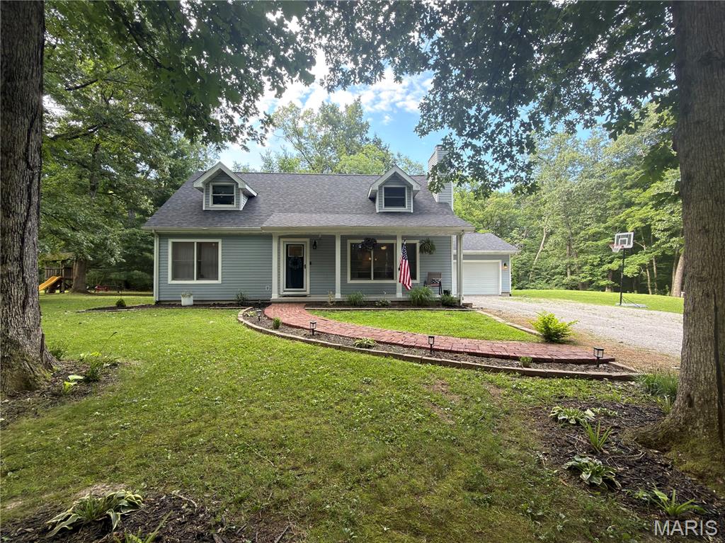 Welcome home to this beautiful 3-bedroom, 2-bath home nestled on a picturesque, tree-lined setting! From the inviting covered front porch and charming brick walkway to the spacious yard surrounded by mature trees, this property offers the perfect blend of privacy and comfort.

Inside, you'll love the beautiful open concept  kitchen featuring stylish gray cabinetry, quartz countertops, stainless steel appliances, and a center island that opens to the dining and living areas—ideal for entertaining. The cozy living room boasts custom built-ins and a stunning woodburing fireplace.

The home also features a 2-car attached garage, newer roof, and a full partially finished basement providing ample storage and flexibility with the additional living space complete with a family room and bar area, perfect for movie nights, game days, or hosting guests. Enjoy peaceful mornings on the covered front porch and evenings in the expansive backyard with plenty of room to play, garden, or simply enjoy nature.

This move-in-ready home offers updated living spaces, charming curb appeal, and a serene setting you won't want to miss! Call your favorite realtor to schedule your showing today.