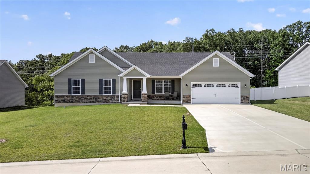 Welcome home to this attractive 3-bedroom, 2.5-bath ranch situated on a quiet cul-de-sac in a desirable neighborhood. A charming covered front porch welcomes you into this well-maintained home featuring low-maintenance vinyl and stone exterior and a 2 car entry with 3-car tandem garage.  Step inside to a spacious living room highlighted by plush carpeting and a cozy electric fireplace, creating the perfect gathering space. The open kitchen offers a large center island, beautiful wood cabinetry, black appliances, a walk-in pantry, and plenty of workspace for cooking and entertaining. Durable wood-look vinyl flooring flows throughout the kitchen, laundry room, and hallways.  The spacious primary suite features a large walk-in closet and a private bath complete with double sinks, a walk-in shower, linen closet, and easy-care vinyl flooring. Two additional bedrooms and a convenient main-floor laundry room provide comfortable everyday living.  The walkout lower level offers endless possibilities for future finishing and includes a rough-in for a half bath. Step outside to enjoy the huge backyard enclosed by a white vinyl privacy fence, perfect for entertaining, pets, play, or relaxing outdoors . With its functional floor plan, generous living spaces, and room to grow, this home is ready for its next owner to enjoy!