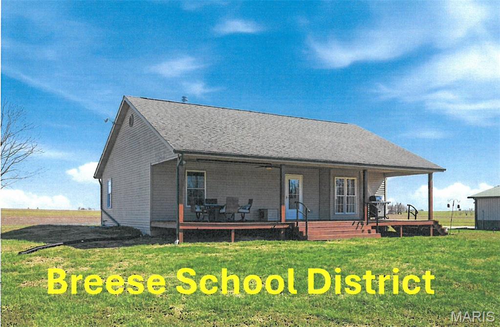 Seeking seclusion? Experience peace and privacy in this ranch -style home set on 20 acres in desirable BREESE SCHOOL DISTRICT.  Tucked away at the end of a private road, the property offers a serene setting with approximately  15 acres of mature timber and a well-stocked 1.5-acre pond featuring bluegill, crappie, catfish, and bass. The home presents a vaulted great room that flows into the eat-in kitchen including all appliances. The primary bedroom offers double closets and convenient access to a 3/4 bath., along with an additional bedroom and half bath that includes washer and dryer. The full basement features  9 ft walls and an egress window providing excellent potential for future living space. A 32 x 40 heated outbuilding with bar area  and refrigerator is ideal for hobbies or entertaining. Enjoy the peaceful surroundings from the covered front porch or unwind in the nearly new hot tub (2024) overlooking the pond. A rare opportunity to own your own private retreat. Lawn equipment and personal property available for purchase. Cameras present at property. Please DO NOT go down private road unless you have a scheduled appointment. Seller request a response time of 6 pm, Tuesday, March 24th on any offers submitted.