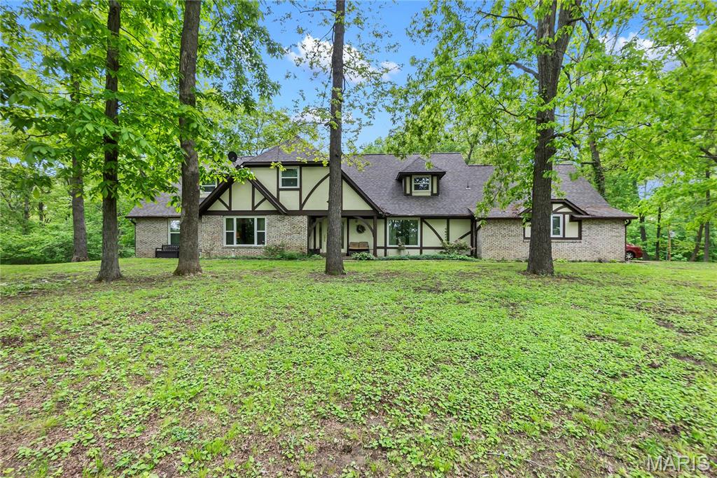A REMARKABLE OPPORTUNITY, Drastic price drop for buyer to make it their own.  To be sold "AS IS".
  An outstanding English Tudor Estate, nestled on 9+ acres and close to I-55. A long private, tree lined driveway, with pond and trees for privacy.   The grand entry foyer with its commanding 2-story, 20-ft cathedral ceilings with curved staircase. Lava rock fireplace is open to 2nd story balcony, open concept. Main level has spacious master suite and bath, dining rm, laundry, powder rm, & screened deck. Bar area between formal living rm with plumbing ran to easily convert to a wet bar.  Also, family rm & baths. Gas fireplace in family rm with electronic lighting. Newer appliances. Range has air fryer setting and large basket. Walkout basement has a spacious living rm with fireplace, full 2nd kitchen, bedroom, sleeping room, 2 full bathrooms, & recreation rm, could be considered an in-law-suite. Home is fortified with steel I- Beam construction & was a custom build. Spectrum high speed internet is available.  Home just received updated electric and well updated to state code.  Pool Table/Ping Pong table to stay.