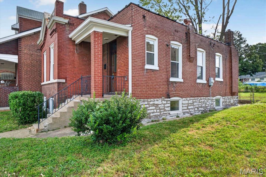 Welcome home to this charming brick bungalow, move-in ready and already passed the St. Louis City Occupancy Inspection! Step inside to find neutral decor and attractive LVP flooring throughout much of the home. Offering 2 bedrooms and 1.5 updated baths, this home also features an updated kitchen and a bright sunroom for additional living space. One bedroom is accented by a cozy, decorative fireplace and pocket door, adding character and charm. Outside, enjoy a fenced yard and an unusually large lot that extends along the alley, providing plenty of green space for entertaining, gardening, pets or play. A garage/carport provides convenient off-street parking. With its classic brick exterior, thoughtful updates, and generous outdoor space, this home is ready for its new owner!