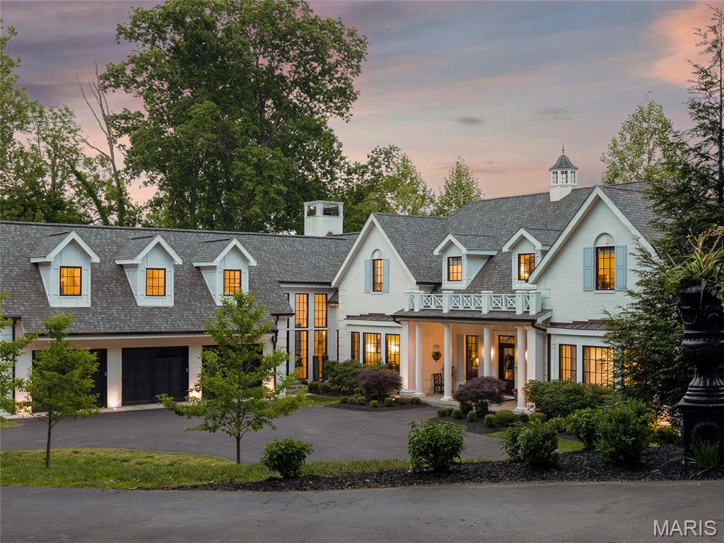 Set on three tranquil acres in Wildwood, this exceptional Cape Cod marries timeless design with a sophisticated, designer-curated aesthetic. Constructed in 2019, the residence was thoughtfully conceived with an intuitive floor plan, striking details, and carefully considered moments throughout.

A breathtaking entry unfolds into the stunning living room, where French doors frame sweeping views of lush greenery and fill the home with natural light. The dramatic dining room, adorned with designer wallpaper, creates an unforgettable backdrop for entertaining. At the heart of the home, the chef’s kitchen balances beauty and practicality with elevated finishes, expansive prep space, and seamless flow into the adjoining living areas. The remarkable hearth room is anchored by a handsome fireplace that rises to impressive 15-foot ceilings, while just beyond, an outdoor patio with its own fireplace invites year-round enjoyment.

The main level is equally suited for everyday comfort, featuring a luxurious primary suite with a spacious walk-in closet and a beautifully appointed bath designed for relaxation.

An architecturally striking staircase leads to the upper level, where two secondary bedrooms and a private office or den are complemented by the convenience of second-floor laundry. The finished lower level offers exceptional versatility with two spacious recreation areas, two additional sleeping rooms, and a full bath — ideal for guests, entertaining, or casual daily living.

Adding to the home’s appeal is a charming attached carriage house above the three-car garage — a truly special retreat offering extraordinary flexibility for extended family, guests, an au pair, or private work-from-home quarters. Complete with its own kitchen, dining area, living room, bedroom, and full bath, the space is perfectly suited for long-term stays or independent living. The oversized garage also includes abundant storage and electric vehicle charging stations.

Peaceful, private, and impeccably designed, this rare Wildwood offering seamlessly blends classic character with refined modern living.