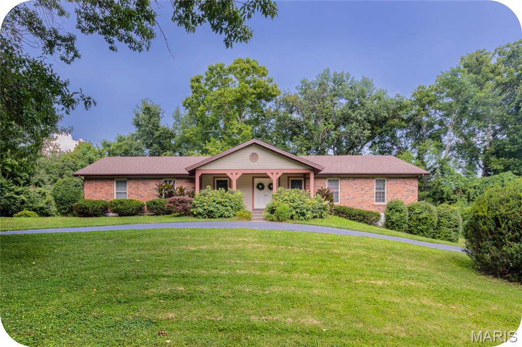 A home owned by the same family for nearly 40 years says a lot. It says the floor plan worked, the setting was worth staying for, and the home was cared for every step of the way. Now, this lovingly maintained ranch is ready for its next chapter. Set on a gorgeous 3-acre lot with a circle drive, charming front porch, and stately double front doors, this 4-bedroom ranch offers the kind of space that's getting harder to find. Step inside to a welcoming entry flanked by formal living and dining rooms before the home opens into an inviting family room anchored by a cozy fireplace. Just beyond, the beautifully renovated kitchen features granite countertops, tile backsplash, stainless steel appliances, double ovens, and an open layout that keeps everyone connected—whether you're hosting the holidays or simply enjoying a Tuesday night at home. Stunning custom hardwood floors run throughout the main living areas, while three secondary bedrooms share a well-appointed hall bath and the primary suite enjoys the privacy of its own bathroom. Out back, the composite deck is made for morning coffee, evening sunsets, and everything in between. Downstairs, the unfinished lower level is a true blank canvas, ready to become whatever your next chapter calls for. A tuck-under 3-car garage, 5-year-old roof, and decades of thoughtful care complete a home that's been updated where it counts and lovingly maintained throughout.