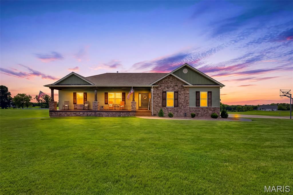 Welcome to 2 Condor Ridge Court! This beautifully maintained home sits on 3 acres, consisting of two lots, and offers a peaceful setting with the community's fully stocked lake directly behind the property. The surrounding landlocked lots also provide additional privacy and help protect the beautiful setting from future development.

The craftsmanship in this home really stands out. Custom real-wood cabinetry, doors, trim and shelving can be found throughout, giving the home a warm, timeless feel. The open main living area features beautiful wood flooring, a stone fireplace, custom wood beams and plenty of natural light. The kitchen is spacious and functional with custom cabinetry, granite countertops, a large center island with seating, stainless steel appliances and a convenient coffee bar. The adjoining sunroom is a wonderful additional living space, offering plenty of natural light and a great place to relax and take in the peaceful surroundings. Just off the kitchen is a dedicated laundry room with additional cabinetry and workspace. 

The primary suite offers plenty of space and features beautiful wood accents, custom made wooden closet barn door, made from an old barn, generous closet space and a large bathroom with double vanities, soaking tub and separate tiled walk in shower. 2 Additional bedrooms provide plenty of room for family or guests, as well as a dedicated office space (or extra sleeping room) off the kitchen area. 

The partially finished basement adds even more usable space and potential. A basement window provides the opportunity for an additional bedroom, and plumbing is already roughed in for a future bathroom. A large unfinished area provides excellent storage or the opportunity to finish additional living space. The basement also features a dedicated vault room designed with concrete construction surrounding the space for added protection and storm-shelter potential. The room currently does not have a door installed, but includes both heating and cooling air returns.

Outside, the covered front porch is a great place to sit and enjoy the peaceful surroundings. The large attached garage provides plenty of room for vehicles, storage and hobbies. With 3 acres, two lots, a stocked community lake and additional landlocked lots behind the property, this is a unique opportunity to enjoy a quiet setting with plenty of room to spread out while still being part of a community.