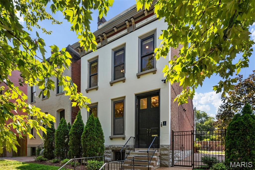 Nestled on a rare double lot in the heart of historic Lafayette Square, this exceptional 3+ bedroom home beautifully blends timeless architecture, natural beauty, and modern livability. A wrought-iron gated fence welcomes you to the second lot/side yard (50 x 122), featuring a brick-paver patio, electronic gated parking, and exceptional privacy. Just steps from picturesque Lafayette Park, neighborhood coffee shops, restaurants, and local favorites, this is truly one of St. Louis’ most walkable and sought-after communities. Rich in historic charm, the home showcases five fireplaces, a grand double-door parlor entrance, soaring ceilings, original refinished hardwood floors, elegant pocket doors, and custom interior shutters. The impressive entry foyer features an original inset mirror and opens to formal living and dining rooms, each with working pocket doors and two of the five fireplaces. A spacious family room with a third fireplace flows into the beautifully updated kitchen with a walk-in pantry. A convenient guest powder room completes the main level. The sweeping original staircase extends to the 3rd floor. The 2nd floor features three spacious bedrooms, a full hall bath, and convenient laundry. The generous primary suite includes a walk-in closet and private access to the third floor—an exclusive retreat featuring a luxurious spa-inspired bath with soaking tub and walk-in shower, an additional walk-in closet, and a private office, library, or 4th bedroom. Outside, the rare double lot provides exceptional space, privacy, and flexibility in the heart of the city. This remarkable Lafayette Square residence offers an extraordinary combination of historic character, thoughtful updates, generous living spaces, and an enviable location. Truly special and offering so much more to discover—this is a home you won’t want to miss!