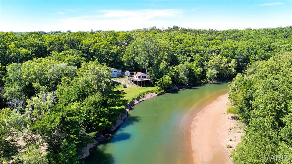 Nestled on a hillside overlooking the beautiful Meramec River, this unique property in St. Clair offers incredible potential as a private residence, weekend retreat, or future bed & breakfast. The home is in need of restoration but features a one-of-a-kind setting with breathtaking river views, mature trees, natural springs, and abundant natural beauty throughout the property. A winding driveway leads down to the home and large recreation building with a spacious deck overlooking the river. The property is located on Old Cove Road with abundant road frontage and just minutes from The River Round Conservation River Access and boat ramp. This rare Meramec River retreat on 3.8 +/- acres featuring artesian well, natural spring water, elevated setting, and exceptional outdoor living space with oversized deck and screened porch. The existing rustic home, screened recreational building and beautiful river will make dreams come true!  Properties with this combination of live water features, privacy, and elevated river setting rarely become available. Don't miss the boat, call today!