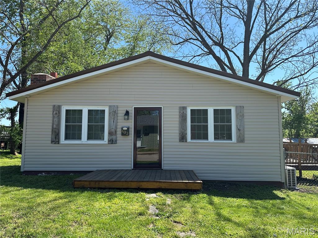 This 3-bedroom, 1-bathroom property sits prominently on a double corner lot and boasts a spacious 60 x 24 garage with an integrated office. The interior living space begins with a combined living room and dining room, featuring a wood-burning fireplace with blower units. The kitchen is positioned conveniently off the dining area. A central hallway provides access to the three bedrooms, the single bathroom, and the laundry facilities housing the water heater. The dining area opens out onto a deck that overlooks a yard with partial fencing. At the rear of the property stands the expansive 60 x 24 garage. New siding was installed in 2025. The metal roof is less than 10 year old. And a new A/C Unit was installed in 2025.