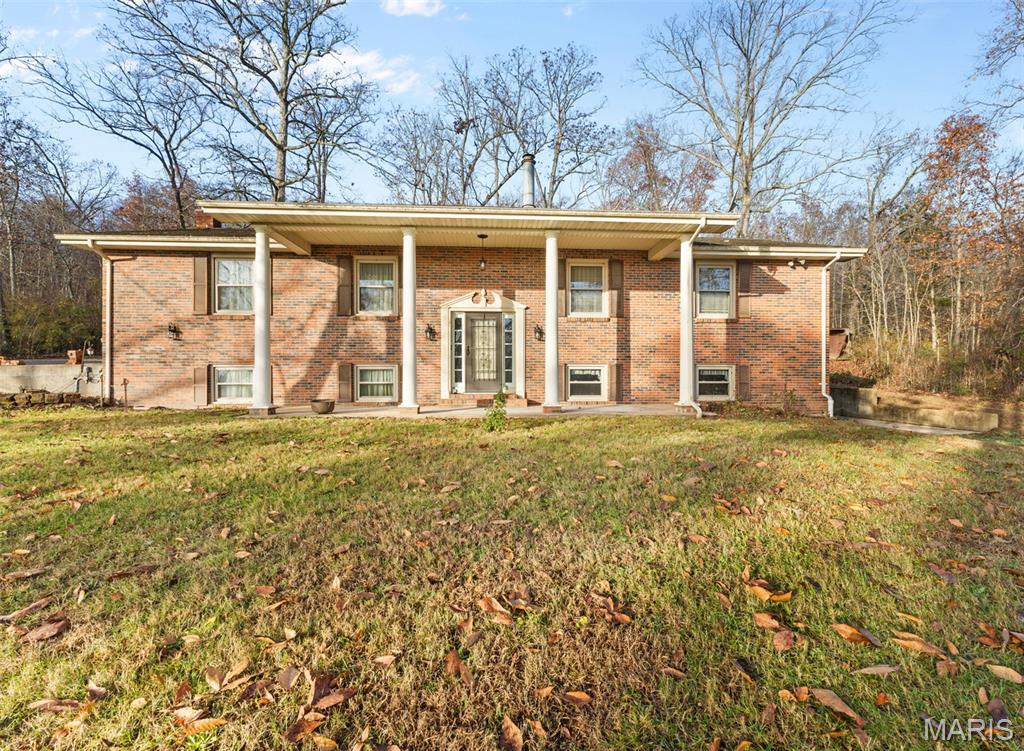 Discover your dream home! This stunning 4 bedroom 3 bath brick residence offers the perfect blend of comfort and style on 5 acres m/l of serene land. The spacious kitchen  features abundant cabinetry and two kitchens. This home boasts a beautiful brick fireplace that adds charm to the large open floor plan, ideal for entertaining. Enjoy meals in the large dining room that easily accommodates family gatherings. With lots of storage space, including built-in shelves, this home ensures that everything has its place. A two car detached garage and an additional outbuilding provide even more options for storage or hobbies. Don't miss this rare opportunity to own a wonderful home that perfectly combines space, functionality, and aesthetics!