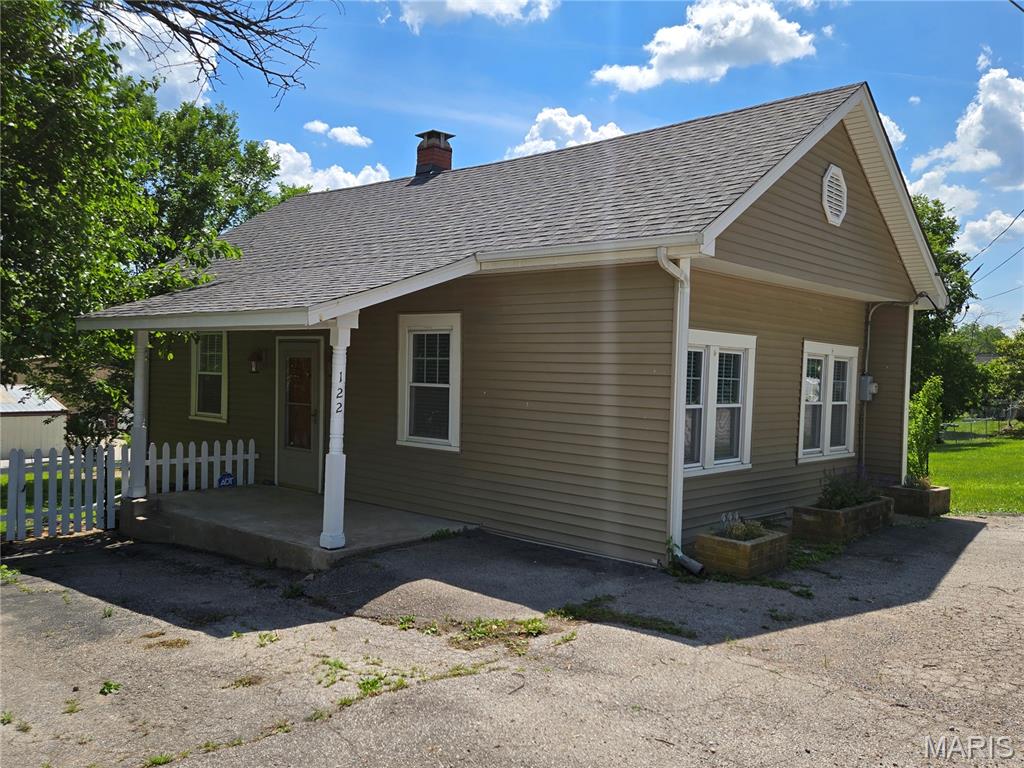 This 1938 cottage in the heart of New Melle offers a quaint, livable space. With about 690 sf, the home features 1 bedroom, 1 bathroom, and a flex room that could easily serve as a second bedroom with an armoire. Laminate flooring runs throughout, and a mix of older wood and vinyl windows keep the home bright and inviting.
The kitchen is functional, with all necessary appliances and room for a small dining table. The living room, with its ample natural light, feels open and welcoming. A small laundry room off the kitchen leads to a deck that's seen better days but still offers outdoor potential.
The basement, accessible via an exterior entrance is constructed of stone, concrete, and cinder block and houses the propane furnace and water heater.  While some repairs and updates are needed, the home is a cute livable space and offers a cozy, small-town feel with mature trees in the yard.  A great chance to make it your own.