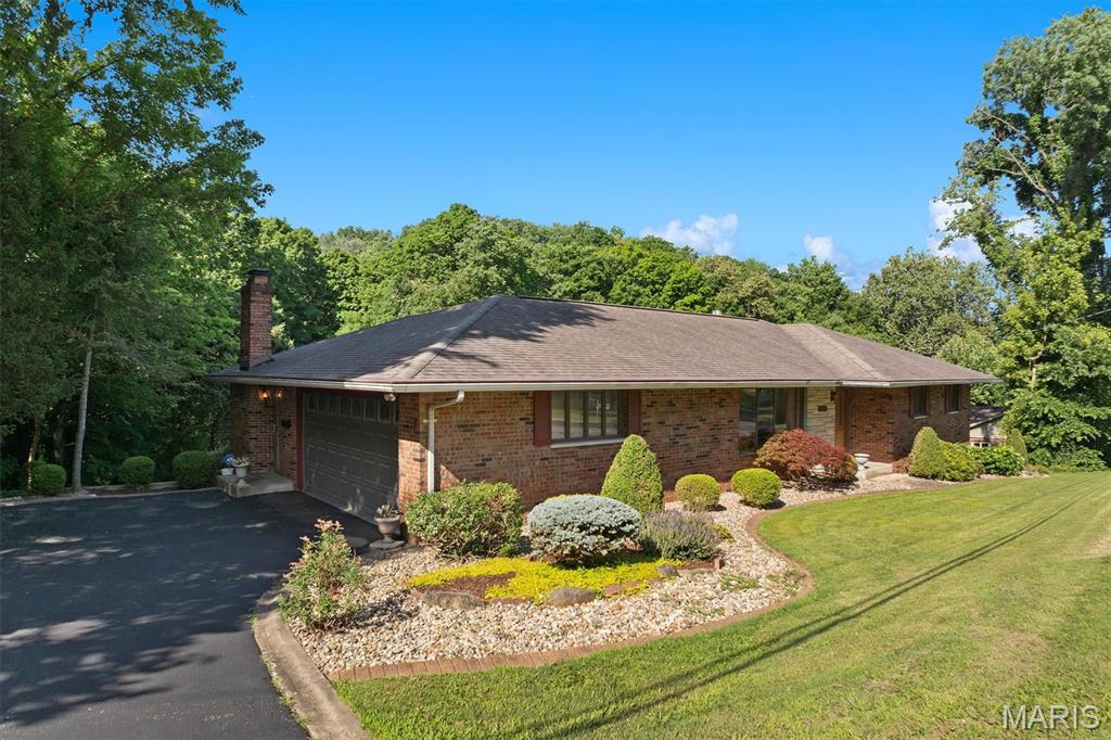 Welcome to this exceptional, well cared for, all-brick ranch where timeless craftsmanship, peaceful privacy, and effortless entertaining come together. Nestled on a beautifully landscaped one-acre lot surrounded by mature trees, this 3-bedroom, 3-bath home offers the perfect blend of comfort, character, and space—just minutes from everything Collinsville has to offer.
Step inside to discover rich hardwood floors, elegant cove molding, bay windows, and inviting living spaces designed for everyday living and memorable gatherings. The spacious main level features a welcoming living room, a cozy family room with a fireplace, and an updated galley kitchen complete with custom cabinetry, granite countertops, pantry storage, open shelving, and a sun-filled window overlooking the backyard.
The flexible French-door dining room can easily serve as a formal dining area, home office, or multi-purpose space to fit your lifestyle. Just beyond, a charming sunroom with a fireplace creates the perfect spot to relax year-round while enjoying views of the outdoor oasis.
Outdoor living takes center stage with a deck overlooking the large in-ground swimming pool and expansive backyard—ideal for summer entertaining, family gatherings, or simply enjoying the peaceful surroundings.
The finished walkout lower level is designed for entertaining and relaxation, featuring heated floors, a large family/recreation room, a full bathroom, a bonus room, and direct access to the pool area. A stately fireplace and generous gathering spaces make this level perfect for game nights, holidays, and hosting guests.
Seller offering a 1 year home warranty from American Home Shield