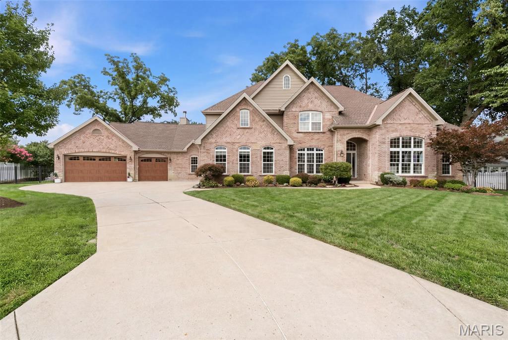 Welcome to 1543 Windridge Court, an exceptional story-and-a-half residence nestled in the highly desirable Harwood Hills neighborhood of Des Peres. Offering 6 bedrooms, 5 full baths, and 2 half baths, this beautifully crafted home combines timeless elegance with thoughtfully designed living spaces. A striking brick and stone exterior and oversized 3-car garage create outstanding curb appeal. Step inside through the impressive foyer, highlighted by an 11-foot barrel-vaulted ceiling, and into the formal dining room that showcases a tray ceiling and wainscoting. The expansive great room features rich crown molding, a floor-to-ceiling stone gas fireplace, and an oversized mantel, creating a warm and inviting gathering space. The gourmet kitchen is designed for both everyday living and entertaining, offering a walk-in pantry, stainless steel double ovens, built-in microwave, dishwasher, five-burner gas cooktop, and an adjoining breakfast room. Just beyond, the vaulted hearth room with a cathedral ceiling and wood-burning fireplace provides a cozy retreat. The main-level primary suite is a luxurious escape featuring a coffered ceiling, bay window, expansive walk-in closet and spa-inspired bath with a jetted soaking tub, oversized shower, and dual vanities. A spacious secondary bedroom with its own private bath is currently serving as a laundry room with 2 sets of washers and dryers. Two half baths complete the main level. On the upper level you'll find four additional bedrooms and two full baths. The fully finished basement features a large recreation area with a kitchen and full bar, an ice hockey training room, a gym/yoga room, and a full bath. Located in one of Des Peres' most sought-after neighborhoods, this exceptional home offers an outstanding combination of luxury, comfort, and convenience with easy access to parks, shopping, dining, and top-rated schools.