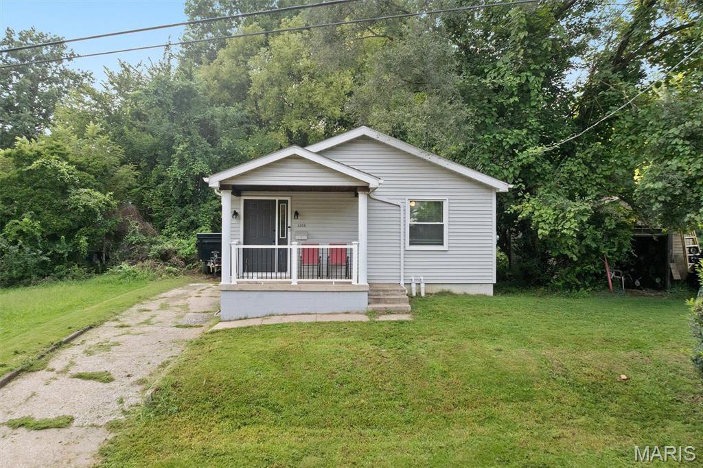 Attention investors or anyone looking for an affordable charming move-in ready home.  A welcoming covered porch invites you into this adorable 2-bedroom, 1 bath home.  Step inside to a bright living room featuring a beautiful bay window, brand new luxury plank flooring, and all new windows throughout, including the basement.  Continue to two nicely sized bedrooms and an updated full bath. The real bonus is downstairs! The spacious basement was fully waterproofed in 2024 and includes a transferable warranty for added peace of mind.  With tons of usable space, you'll find a room with a toilet and plumbing for a future sink., an additional area with great potential for a family room, entertaining space, plus plenty of storage.  This space is just waiting for your personal touches. Outside enjoy a covered patio and a 1 car detached garage.  Updates include windows, gutters, electrical box, and basement waterproofing in 2024 new water line in 2025. This home is being sold as is, but the seller will pass city occupancy for the buyer's convenience.