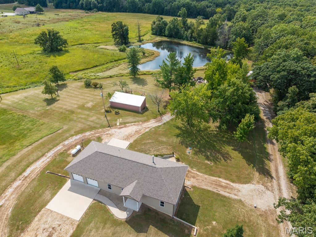 Country living meets modern functionality at this 20± acre property just outside Auxvasse. Built in 2021, the ranch-style home offers approximately 2,220 square feet of finished living space with five bedrooms and three full bathrooms. The main level includes three bedrooms, two bathrooms, an open kitchen and living area, and a convenient laundry and utility room. Downstairs, the partially finished walk-out basement adds two bedrooms, a full bathroom, a central living area with a wood-burning stove, and abundant storage space.

Outside, the property offers plenty of room for vehicles, equipment, and recreational use. The oversized garage features two doors on the front and a two-car garage door on the back. It can accommodate up to four vehicles, along with lawn equipment, recreational gear, and additional storage. Other improvements include a 24-by-36-foot shop with a concrete floor and electricity and a 16-by-40-foot livestock shelter.

The acreage includes open ground suitable for hay production or horses, a pond, and a wooded draw that provides wildlife habitat and hunting potential. The back 10± acres offer a strong setting for hunting and a potential food plot. The hay ground has also generated annual income.

The home is served by a public water and private septic/lagoon system, Callaway Electric, propane, and fiber-optic internet. Located less than 15 minutes from Kingdom City and I-70, the property provides convenient regional access. Columbia is roughly 40 minutes away, making this a practical option for buyers seeking rural living within commuting distance.