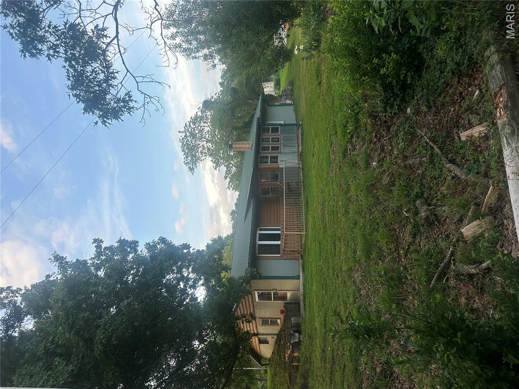 Beautiful Energy-efficient Earth Berm Home with Log siding in the Rogersville School District, 3 Bedrooms ( one is non-conforming) and 2 full bathrooms. Situated on Acreage in the country. Equipped with a wood-burning stove and a wall-hanging propane heater. Do you enjoy Fast Cars and Drag Strip Action? You are within walking distance of the Drag Strip Raceway! There is a Concrete pad waiting for your dream shop to be constructed! With plenty of outside parking spaces. There is a glass-enclosed front porch for not-so-perfect days! The greenhouse is being removed, which leaves you with the perfect garden spot with a water hydrant nearby. Will be ready for your Dream Garden! Interested in an above-ground swimming pool? With some elbow grease and some TLC, you can be soaking away those hot days of summer. Country Home. Horses allowed