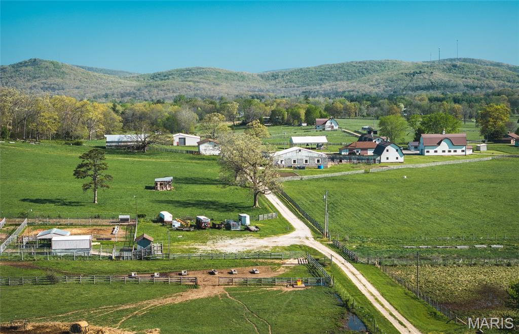 Don’t miss out on your chance to own one of the most beautiful farms in the valley! Conveniently located just outside city limits on Hwy 72 in Ironton, this remarkable property offers everything for the outdoor enthusiast, cattle rancher, or horse lover. Land & Water: Over half of the 686 acres is lush pasture, fully fenced and cross-fenced with automatic waters in every field. A natural spring provides water to the entire farm, complemented by a spring-fed pond and a 1+ acre stocked pond—perfect for livestock and recreation. Buildings & Improvements: This property is loaded with infrastructure, including two large hay barns (60x180 and 69x100), a 60x60 covered fire pit pavilion, a 1,980 sq. ft. office with 5 rooms, 2 bathrooms and a new metal roof, a 30x70 shop with new roof, a 75x50 block building with RV doors, a 60x48 tractor shed also with RV doors, and a 30x60 feed shed.  Horse Facilities: Equestrians will love the four barns with a total of 43 stalls, each with hay lofts. At one point, one of the lofts was used as beautiful wedding venue! Facilities include tack rooms, wash areas, and bathrooms—ready for training, boarding, or breeding operations. Livestock & Equipment: The farm is fully equipped with 4 sorting pens, a working chute with head gate, loading/unloading chute, digital livestock scale, tractors, trailers, and additional equipment included. This farm is truly a turnkey operation, ideal for cattle, horses, or recreational use. It also has endless possibilities for revenue. With its size, water sources, and extensive facilities, it’s a rare opportunity to step right into a fully functioning agricultural paradise.