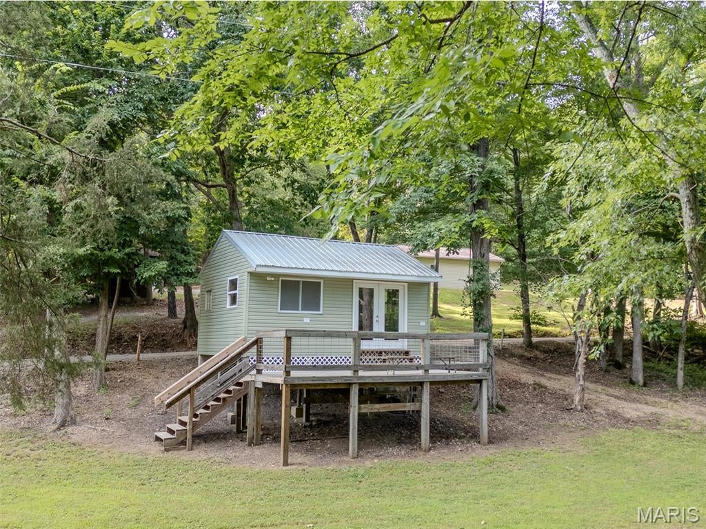 If you’ve been looking for a peaceful river getaway with hard to find private access, this cozy cabin overlooking the St. Francis River is it! Sitting on two lots totaling over an acre, the property is in great condition, well cared for, and ready to enjoy from day one. One of the biggest highlights is the property’s private boat ramp, one of only a few in the area. It provides convenient access to a beautiful, quiet stretch of the St. Francois River perfect for fishing, floating, kayaking, or simply spending the day relaxing on the water. The cabin features one large, open living area with a half bath divided off, making it a simple and comfortable place to spend weekends or extended stays. While there is no well, the property is equipped with a water holding system and pump that supplies water to the bathroom. 
Outside, the excellent lay of the land adds even more possibilities. The mostly flat ground provides plenty of usable space and would be ideal for family and friends to bring their RVs and make a weekend of it. With over an acre to spread out, river views, your own boat ramp, and a cabin that needs nothing, this property offers the perfect recreational setup.