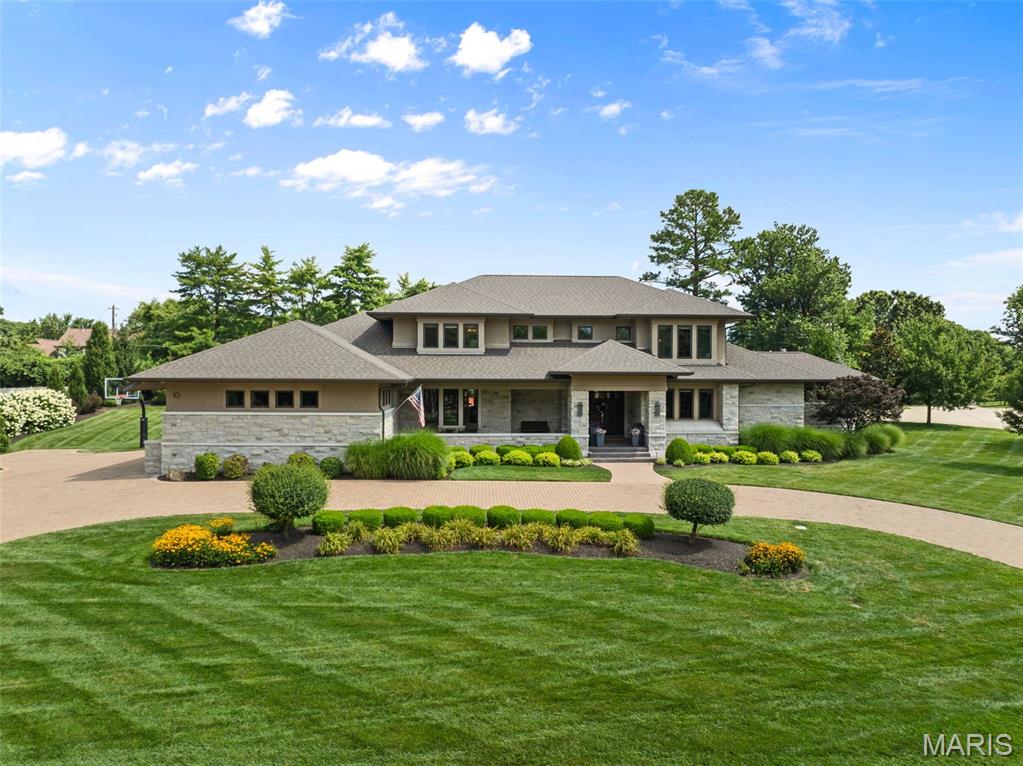 Beyond its stately presence and impeccably manicured grounds lies a residence thoughtfully designed for a life well lived. Offering more than 8,000 square feet of beautifully appointed living space, this extraordinary home balances grand-scale entertaining with the warmth and comfort of everyday living.
The heart of the home unfolds through expansive gathering spaces filled with natural light and refined architectural details, seamlessly connecting to the breathtaking outdoor oasis beyond. Whether hosting elegant celebrations or intimate evenings with family, every room has been curated to inspire connection. Privately situated on the main level, the luxurious primary suite offers a peaceful sanctuary, while a richly appointed office, private fitness studio, and multiple entertaining spaces create an effortless lifestyle. Two powder rooms and laundry facilities on every level reflect the thoughtful attention to convenience woven throughout the home. Upstairs, four generously sized bedrooms and three beautifully finished baths provide exceptional accommodations for family and guests. Two of the bedrooms feature charming adjoining lofts, creating magical spaces for reading, studying, play, or quiet retreat. The lower level extends the home's exceptional livability with a sprawling recreation room designed for unforgettable game days and movie nights, an additional guest suite with a full bath, and an expansive workshop complemented by remarkable storage and custom shelving. Step outside, and everyday life begins to feel like a luxury vacation. Framed by mature landscaping and lush lawns, the resort-caliber backyard is a private escape centered around a sparkling pool and an extraordinary pool house designed for year-round enjoyment. Complete with a full bath, stylish entertaining lounge, bar, and hot tub, it's a destination all its own—perfect for summer afternoons, evening cocktails, and gatherings that linger long after sunset. Set within the prestigious enclave of Sackston Woods, this exceptional estate offers the rare combination of privacy, sophistication, and effortless luxury, just moments from the finest dining, shopping, and amenities that make Creve Coeur one of St. Louis' most sought-after addresses. More than a home, 10 Sackston Woods is a place to gather, celebrate, and create a lifetime of memories.