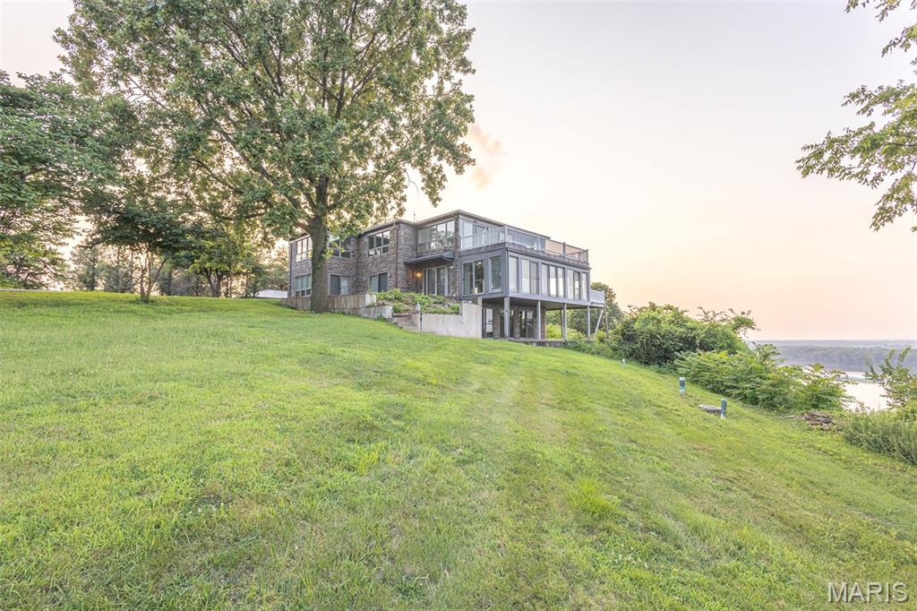 Perched high above the Mississippi River on 9.7 scenic acres just outside of Hannibal on Highway 79, this custom-built 5-bedroom, 4.5-bath home offers breathtaking panoramic views and a truly one-of-a-kind setting. Built in 2003, the home was thoughtfully designed to take full advantage of its bluff-top location, with expansive windows and an open floor plan that capture the beauty of the river from nearly every room. The spacious main level features a four-season screened porch, while the upper-level deck provides the perfect place to enjoy river traffic, abundant wildlife, and spectacular sunrises and sunsets. Whether entertaining guests or enjoying a quiet morning with a cup of coffee, the views are simply unmatched. A private asphalt driveway leads to the home, where you'll find both an attached garage and a detached garage, providing ample space for vehicles, recreational equipment, hobbies, or a workshop. Surrounded by mature trees and beautifully maintained grounds, the 9.7-acre property offers the ideal combination of privacy, natural beauty, and convenience. 

Properties like this rarely come to market. With incredible Mississippi River views, quality custom construction, generous indoor and outdoor living spaces, and an unbeatable location just minutes from Hannibal, this exceptional property is a rare opportunity to own one of Northeast Missouri's premier bluff-top homes.