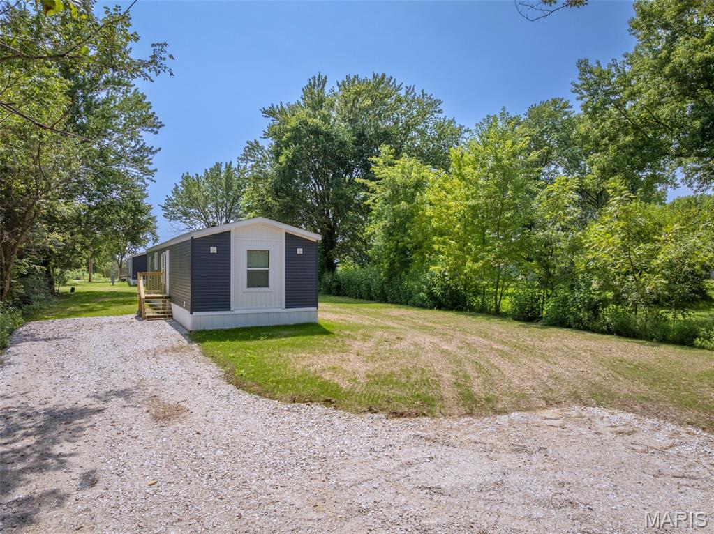 3 words you don't ever hear together, nice, new, affordable! Brand new 3 bedroom, 2 full bathroom manufactured home affixed to a city lot in the quiet country town of Truxton, Missouri. Home comes stocked with a stove, overhead microwave and refrigerator making it move in ready. Master bedroom features a walk in closet and en suite bathroom with step in shower and is big enough to fit a king sized bed. Galley style kitchen is upgraded with extra cabinet and counter space giving you the perfect place to prepare a meal. The living room gives you enough space for a sectional, recliner and entertainment center but with the front porch, and shaded lot, you won't be spending any time inside! The lot it sits on is level and ready to build a shop or shed on with ease. Located just a few miles from Highway 70 and not far from Warrenton, Hawk Point and Troy. Connected to a shared well and public sewer. Gutters getting installed in the next couple of weeks. Extra wall panels and trim in living room will be removed prior to closing unless specified by buyer. Agent Owned