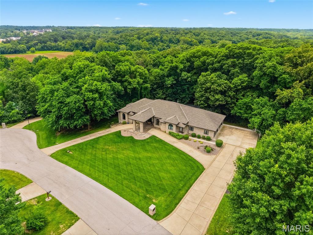 Welcome to your DREAM HOME, where country living meets convenience, just minutes from town. This spectacular custom-built, mostly brick ranch sits on a 3-acre lot in highly sought-after St Paul. It is nestled on a quiet cul-de-sac in the prestigious Summit Estates Subdivision. Boasting nearly 5,000 finished square feet, a 4-car oversized garage and an open floor plan, this home offers luxury, serenity, and ample space for both entertaining and daily living. ----- 

Step inside to discover soaring 11-foot ceilings and beautiful hardwood floors throughout much of the main level. The expansive great room, featuring a gas fireplace, opens to a massive 56’ x 14’ deck that overlooks the private backyard. Adjacent to the great room is a formal living room and dining room, ideal for hosting guests. The gourmet kitchen impresses with rich hickory cabinets, granite countertops, a double oven, pantry, stainless steel appliances, and a spacious bay-window breakfast area. (Dishwasher & Refrigerator are 1 yr old). ----- 

The luxurious primary suite provides a true retreat experience, complete with a gas fireplace, private sitting area, two walk-in closets, and a BRAND-NEW SPA LIKE BATHROOM featuring dual vanities, quartz counters, a soaking tub, and an oversized walk-in shower. Private deck access from the primary suite leads directly to the relaxing two-year-old hot tub or a place to sit & enjoy the birdsong & your morning coffee. A thoughtful split-bedroom design offers two additional generously sized main-level bedrooms each with their own full baths, and a bright office / den with a bay window and peaceful wooded view. ----- 

Downstairs, the walk-out lower level is designed for entertaining, offering a spacious family room, billiards and game area, impressive wet bar, two additional large bedrooms—including one wired for a media or theater room—another full bath, and abundant storage. Stepping out from this level, you'll find a sprawling patio that seamlessly transitions to a fully fenced backyard, bordered by tranquil woods for unparalleled privacy. The expansive outdoor space is perfect for hosting memorable family barbecues, providing ample room for gatherings both large and small. Children and dogs alike will enjoy the freedom to play and explore. ----- 

Additional features include an oversized four-car side-entry garage with new doors and a second staircase to the lower level, a circle driveway with ample parking & aggregate trim, a porte-cochere covered drive through with newer stamped patio at the front entry to keep you protected from the elements, a front yard in-ground sprinkler system, newer retaining wall, attic fan, water softener, dual HVAC systems and water heaters, and a main-floor laundry room with laundry sink & additional hookups on the lower level. Included with the home are the two-year-old hot tub, one-year-old stainless-steel refrigerator, one-year-old washer and dryer, and a lower-level wine cooler. This exceptional property is truly a must-see, set up your tour today!
