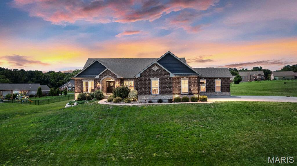 Welcome to 250 Pintail Drive in Old Monroe, where peaceful country living meets exceptional entertaining. Nestled on over an acre, this stunning 5-bedroom, 3.5-bath home is filled with custom unforgettable "WOW" spaces.

Step inside to an open floor plan highlighted by custom stone accents, a one-of-a-kind vintage window cutout in the dining room, and a spacious great room featuring a floor-to-ceiling stone gas fireplace with built-in display niches. A wall of windows with plantation shutters fills the home with natural light.
The chef's kitchen is designed to impress, offering double wall ovens, a gas cooktop, stone hood vent, and 2 pantries. The adjacent laundry room includes a utility sink, cabinetry & Shelving.

Retreat to the luxurious primary suite featuring a tray ceiling, large walk-in closet, dual vanities, private water closet, and a "WOW" walk-in glass shower with dual shower heads. Three additional bedrooms complete the main level, including one currently used as a custom dressing room with direct access to the guest bath.

The finished walkout lower level is an entertainer's dream with a custom "WOW" full-stone wet bar, ceiling-mounted projector, pull-down screen, dedicated exercise area, office, fifth bedroom, full bath, and storage with wood shelving.

Outside, the showstopper is the custom "WOW" pavilion featuring a wood-burning fireplace, unique lighting fixtures, built-in kegerator, gas grill, beverage cooler, and included hot tub. Whether hosting friends or enjoying a quiet evening, this outdoor retreat is designed to create lasting memories.
This extraordinary "WOW" property offers countless custom details and amenities that must be seen to be fully appreciated. Schedule your showing today!