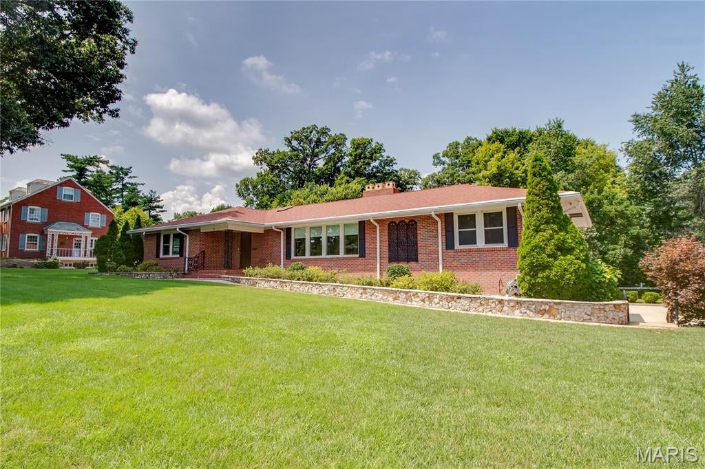 Welcome to this sprawling brick ranch nestled within Fairmount, where beautifully maintained grounds and a peaceful setting create an exceptional place to call home. Meticulously cared for by its owners, this home offers generous living spaces, timeless brick construction, and an abundance of natural light throughout.

The main level is designed with entertaining in mind, featuring an extra-large formal living room with a wood-burning fireplace, a spacious family room surrounded by windows overlooking the manicured backyard, and a dining area that provides plenty of room for gatherings. The main floor offers two bedrooms plus a third bedroom currently being used as an office, complete with built-in cabinetry and parquet flooring.

Downstairs, the fully finished walkout basement expands the living space considerably. A second family room with another wood-burning fireplace provides a comfortable gathering space, while an additional oversized sunroom-style room is filled with windows and offers beautiful views of the grounds. The lower level also includes a laundry room and kitchenette with additional appliances, creating excellent flexibility for guests, extended family, a hobby space, or a potential mother-in-law suite.

Outside, the property truly shines. The grounds have been exceptionally maintained, with an expansive lawn that reflects the tremendous care that has gone into the landscaping and outdoor maintenance. With its open, lush setting, the yard is a gardener’s dream. An additional storage shed provides convenient space for tools and equipment, supporting any gardening or outdoor hobby needs. Gutter helmets have also been installed on the gutters, adding ease of maintenance and long-term protection. A concrete driveway leads to the two-car tuck-under garage, while an additional three-car parking pad provides plenty of room for guests and entertaining.

Additional features include a roof approximately six years old and furnace and air conditioning approximately eight years old. With its substantial living areas, two fireplaces, finished walkout lower level, exceptional outdoor spaces, and meticulous maintenance, this is a home that offers both comfort and versatility in one of the area’s most desirable settings. Classy and timeless in design, this property is ready to be enjoyed for years to come.