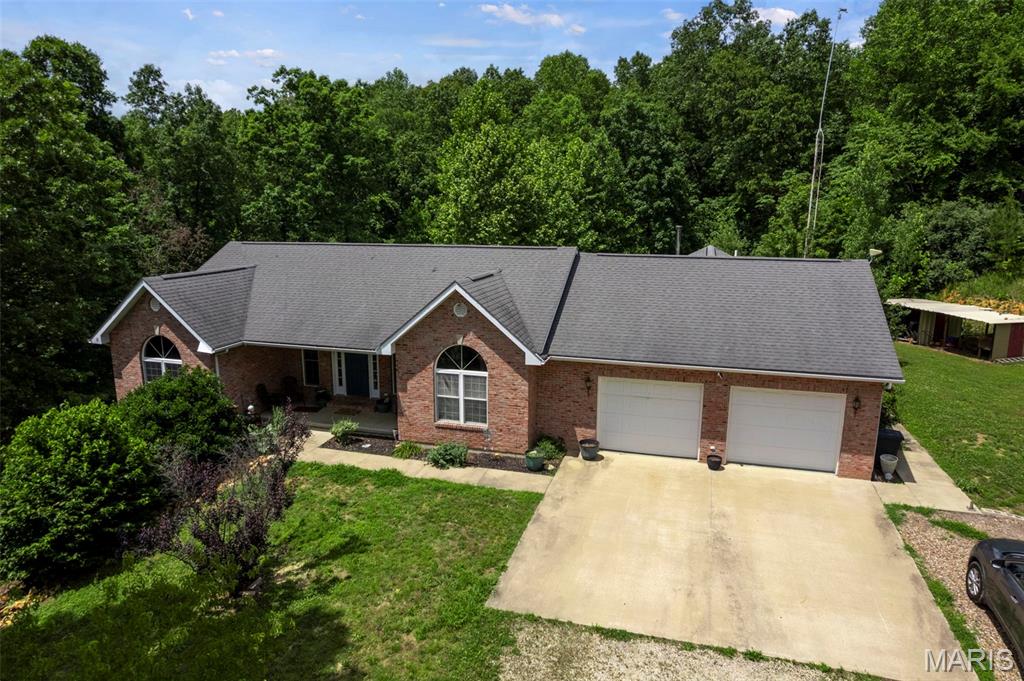 Spacious 5-bedroom, 3-bath ranch situated on 2.24 private acres and backing to beautiful woods. This inviting home features vaulted ceilings, an eat-in kitchen, and generously sized closets throughout. The main level offers a desirable split of living space, including the primary suite with private bath, two additional bedrooms, a full bath, and convenient main-floor laundry. The lower level provides added privacy with two additional bedrooms, a full bath, and a spacious great room perfect for entertaining, recreation, or relaxing. You'll also appreciate the abundant storage space throughout the lower level. Enjoy the peaceful setting from the private front porch or unwind on the deck overlooking the backyard and wooded views. Complete with a 2-car garage, this property offers the perfect blend of space, comfort, privacy, and country living.