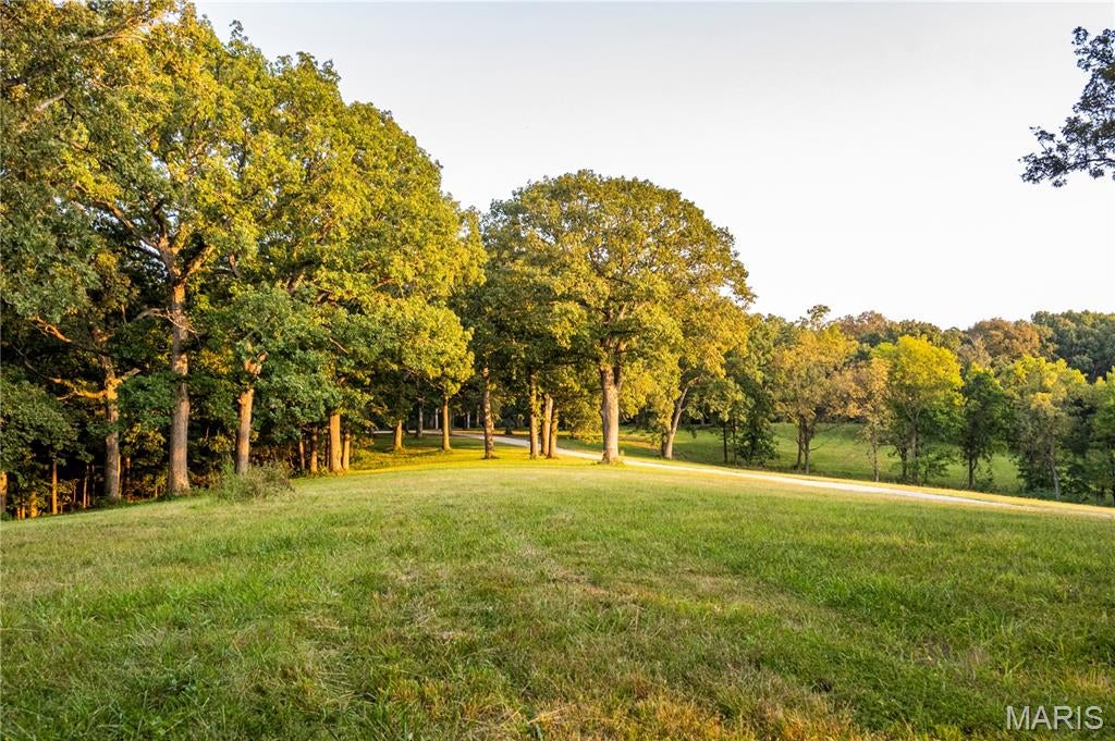 Experience the perfect blend of natural beauty, privacy, and modern convenience on this stunning 12.1+/- acre property featuring underground utilities, including electric and county water. Surrounded by mature hardwood trees and offering breathtaking lake views, this beautiful tract provides multiple exceptional building sites for your dream home, shouse, or barndominium. Abundant wildlife, including turkey and impressive whitetail deer, makes this property an ideal retreat for nature lovers, hunters, and outdoor enthusiasts. Protective deed restrictions help preserve the beauty and privacy of the property, allowing up to two homes with a minimum of 1,200 sq. ft. each while prohibiting subdividing, mobile or modular homes, hog confinement buildings, junkyards, racetracks, VRBO/Airbnb use, and logging except for building purposes or removal of dead trees. Additional acreage is available, with an additional 11.4+/- acres bringing the total potential acreage to approximately 23.6+/- acres. This is a rare opportunity to own a beautiful piece of country property with stunning views, abundant wildlife, utilities already in place, and the perfect setting for a custom country home, private homestead, or recreational getaway. Deer photos are from the parent tract and may or may not have been taken on this specific parcel. Agent owned.