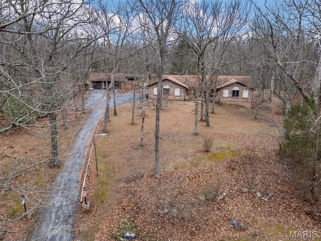 *Buyer financing fell through, their loss is your gain* Nestled on over three private acres in Fawn Run, this home provides the space you have been looking for.  The Spanish-inspired ranch features two distinct living spaces: the upper level with 3 bedrooms and 2 full baths, and the lower level featuring an additional 2 sleeping spaces and a full bath. The main level boasts a kitchen with granite counters, overlooking the large deck with an above-ground pool and hot tub, and is open to the living room, while still accommodating a formal dining room, laundry room, and large main-floor family room.  The attached oversized 2-car garage features a ramp for easy access to the main floor, while upstairs bathrooms have been updated with features to enhance ease of use for those with mobility challenges. The lower level walks out to the side yard via a sliding door, perfect for multigenerational use.  There are multiple outbuildings, including a 3-car garage with an additional space for your RV or large boat. This sprawling property is in the Francis Howell School District in Wentzville and provides easy access to shopping and highway access.  This home is all electric and just waiting for you to make it your own. Sale to be as-is. Seller to do no repairs