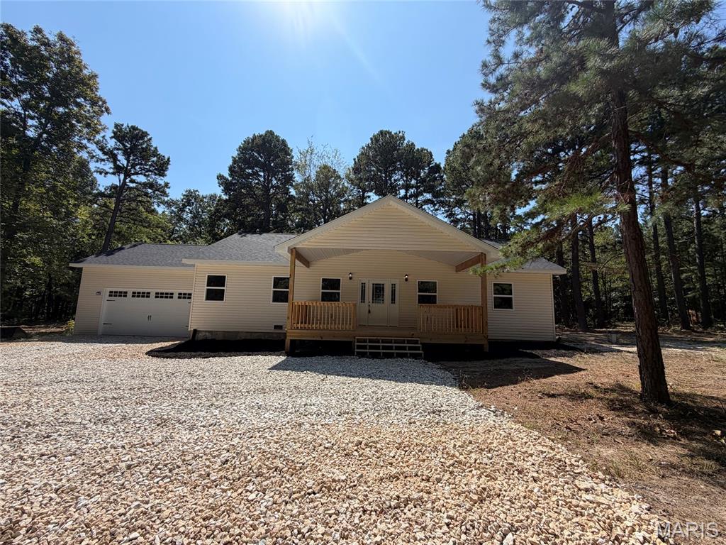 Brand-New Construction on +/- 3.32 Wooded Acres Just Minutes from Rolla! Experience the perfect blend of modern style and peaceful country living in this beautiful 3-bedroom, 2-bath home offering approximately 1,500 sq. ft. of thoughtfully designed living space. The open-concept floor plan is ideal for both everyday living and entertaining, featuring a spacious kitchen with a center island, custom cabinetry, and seamless flow into the living and dining areas. Luxury vinyl plank flooring extends throughout the home, providing both durability and style. The private primary suite includes a full bath with a double vanity and step-in shower, creating a relaxing retreat at the end of the day. Step outside to enjoy the covered front porch or unwind on the back deck overlooking the mostly wooded setting, offering privacy and room to explore. An attached 2-car garage provides added convenience and storage. Enjoy the beauty of new construction with the tranquility of country living—all just minutes from Rolla. Schedule your private showing today!