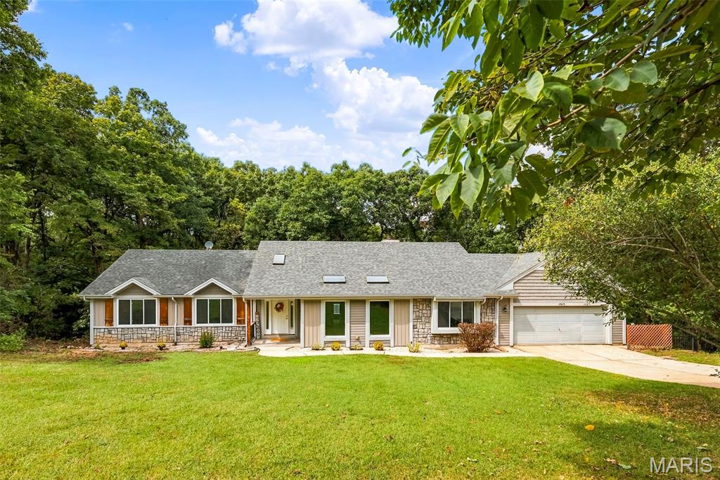 Tucked away on four beautiful acres, this spacious four bedroom, three bathroom offers the perfect blend of privacy and comfort. Just off the entryway, a gorgeous atrium creates a dream for plant lovers. The spacious vaulted living room is the heart of the home with cherry wood floors to die for, stunning wood beams and a cozy wood burning fireplace for memories to be made here. The updated kitchen has light wood 42' cabinets and quartz countertops. All Stainless Steel appliances and a garbage compactor as well as a walk in pantry with washer and dryer hook up. In the lower level the possibilities continue with an expansive media room, perfect for movie nights, game days or any type of entertainment that fills your cup. There is a bonus room connected to the media room that you could use for a private office. The home also includes two walk outs, one in the third bedroom and the other in the fourth room that you could use for a gym, craft room, or even a large kids playroom! The unfinished basement has plenty or storage as well as a secondary washer and dryer hook up. Enjoy the gorgeous wooded backyard on one of the two composite decks. The yard is fully enclosed with a black aluminum fence, perfect for the man’s best friend. The home also has an oversized garage nice for adding a workstation or a couple of extra toys. If you have been searching for a home that boast in enjoying the beauty of nature, as well as having plenty of room to entertain, this home is waiting for you to call it your own!