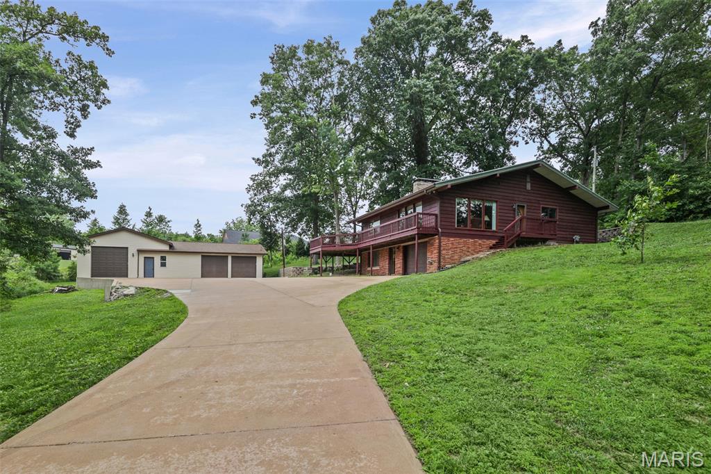 Looking for privacy? Nestled on approximately 1 acre, this 3-bedroom, 2-bath home offers the peaceful setting you've been searching for. Inside, you'll find two fireplaces that add warmth and character, while outside, the spacious deck is the perfect place to enjoy your morning coffee or unwind while taking in the surrounding views. Car enthusiasts, hobbyists, and RV owners will appreciate the impressive 4-car garage with dedicated RV space and electricity. With plenty of room for parking and storage, this property offers endless possibilities. Sold as is.