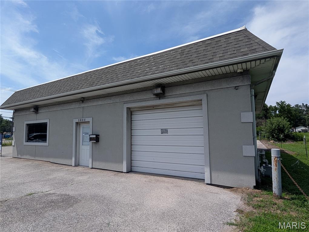 Commercial property on a high-visibility lot. Sitting on two spacious lots with excellent frontage at a busy intersection, this building offers prime exposure for any business. Features include a large blacktop parking lot, a well-appointed office area, a convenient half bath, & a utility room with laundry hookup. The large service bay includes two sets of hot/cold water hookups and heat, front and rear garage doors, while the 2nd small bay has a rear garage door and offers both heating & cooling along with the rest of the building. Bays can accommodate 3/4 vehicles, ideal for auto or motorcycle work. Previously used as a motorcycle dealership & a detail shop, this versatile space offers strong potential for a new business or rental opportunity. Ready for its next owner to capitalize on its location and commercial potential!