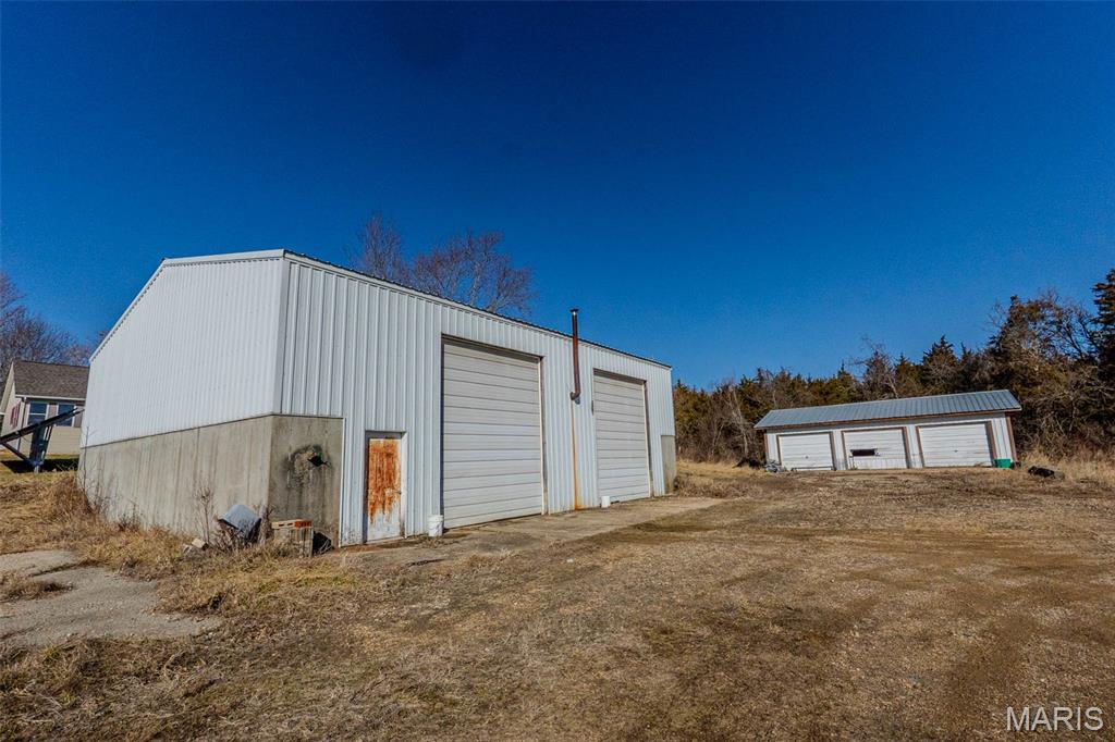 Two outbuildings on 1.9 acres m/l offering great warehouse and storage potential. Five total garage doors provide easy access. Property is on public sewer, has wood heat only, and no water is currently connected. Located off Lions Club Drive. Ideal for warehouse, storage, or contractor use.