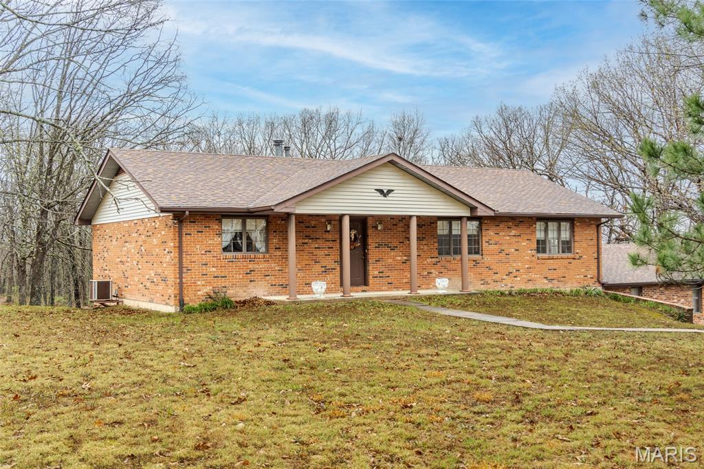 PPROFESSIONAL PHOTOS ComingThursday! Discover peaceful country living on 14.5 beautiful acres with this full-brick home offering a comfortable space and just minutes from I44. Inviting open floor plan, with hardwood floors, seamlessly connects the living room, kitchen, and dining areas.  Large deck for relaxing or grilling. Custom kitchen cabinetry, breakfast bar, gas range & refrigerator stay, and lots of countertops for meal prep for the chef in your household. Main level features two generous sized bedrooms and two full baths, which includes the comfortable primary suite. Large Anderson windows throughout afford the new owners the opportunity to take in the sights of nature.  Lower level is mostly finished and expands your living space with a large rec room (pool table stays) complete with a bar, kitchenette, possible third bedroom, and third full bath. A walkout patio adds even more room to relax or entertain.  Car enthusiasts, hobbyists, or anyone needing extra storage will appreciate the oversized 2-car attached garage plus a 24x40 detached garage/outbuilding.  Roof replaced Dec 2024; furnace is propane, &/or inside wood furnace.  Detached garage woodstove stays.   Additional adjoining12.1 +/- acres available to purchase for $120,000.  If you’re looking for a quiet, private setting without sacrificing convenience, this property delivers the best of both worlds.  Showings start April 3, 2026.