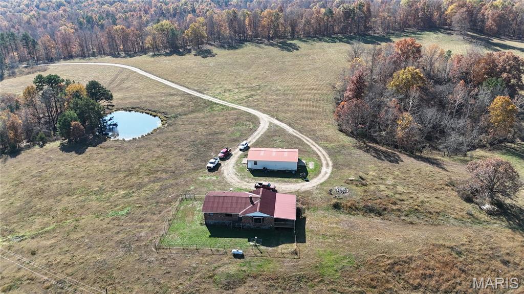 244 acres of pure beauty  surrounds you when you enter this property, the long private drive from the gate to the house is alluring. The House is located near the center of the property with territorial panoramic views, you can look out the windows or from the 33 x 16 covered deck and oversee the majority of your property. This feature is great because this was a working cattle farm for the past 60 + years and if Cattle is your thing you could step right in and start right up. This property is perimeter fenced and cross fenced  with T post along with the majority of the H braces at the ends and corners being  constructed of welded metal pipe, all recently done. The pastures are well established and are clear of rock and debris , They also have some of the richest soil in this county with an NCCPI rating of 62.6 on the pasture ground which translates into a nutrient rich hay crop with the possibility of two cuttings dependent on grazing. The average NCCPI rating for Reynolds county is 27.7. There are two deep wells on the property and a anti freeze waterer, metal pipe corral panels form a paddock with chutes a cattle scale and a Priefert brand squeeze chute all included. If Cattle isn't your thing this property lends itself to a peaceful retreat for a full time residence or weekend getaways. the house dates the mid 1980s and is well built, it features a full brick veneer with two full baths and 4 bedrooms the kitchen is large with a  island bar and  separate dinning area, the house is in good condition but could use some updates.  There is a mix of woodlands and pastures with multiple ponds some stocked with fish. The hunting and fishing is excellent on this property. this property also lends itself  to horses or other livestock with the pasture quality making it ideal for grazing animals or crops. If you don't want to hang out at the ranch there are many attractions nearby including the Black river, Johnson's Shut-Ins state park, the Current River Conservation area and Clear Water Lake just to name a few. whether this will be a full time residence or a weekend getaway this place is truly a piece of paradise. make an appointment and come check it out, it will not disappoint. as of may 2026 a fiber optic internet connection was installed in the residence. also see MLS listing  25082748 for an additional  228 acres 1/4 mile away (still in view of main farm) or MLS listing 25082673 for both listings combined