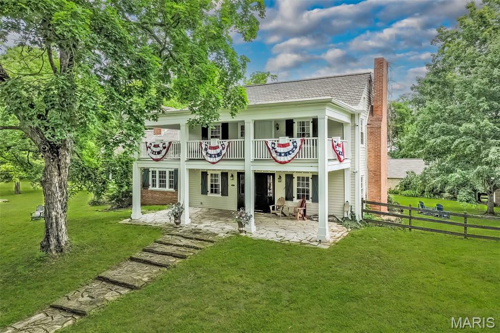 This historic estate is truly one in a million, where a majestic tree-lined lane beckons you to an era gone by. Perfect for a year-long residence or a host of other options--you decide! Too many INCREDIBLE features to list! Situated on 14 sprawling acres, the original farmhouse was built in 1840 w/an addition completed in 1930, DOUBLING the home's size. A grand front porch/balcony says welcome! Inside, you are greeted w/the charm of original pine wood floors, 6 fireplaces, wall sconce lighting, a multitude of built-in bookcases & period millwork. TWO cozy living areas & a LARGE dining rm w/two built-in corner cabinets are perfect gathering places. GOURMET kitchen is a chef's dream w/FULL side-by-side refrigerator/ freezer, TWO dishwashers, 4-burner gas range cooktop w/grill, griddle & TWO ovens, marble countertops, HUGE island & a perfect blend of newer & original cabinetry w/glass fronts. A cozy library w/rich paneling, fireplace & built-in bookcases, den/bonus room, mudroom/laundry & half bath complete the main floor. Upstairs are FOUR bedrooms & 2 full baths-both recently renovated! A renovated guest cottage offers 2 additional bedrooms & 1 full bath. PLUS: All-stone 4-car carriage house; 30'x50' climate-controlled shop (6-car) w/half bath & loft area; original stone coal storage room converted to 2 event restrooms; fenced dog-run; 20'x40'; chicken coop; NEW pavilion for equipment storage. Perfect for horses, etc. METICULOUSLY cared for inside & out--a MUST SEE to believe!